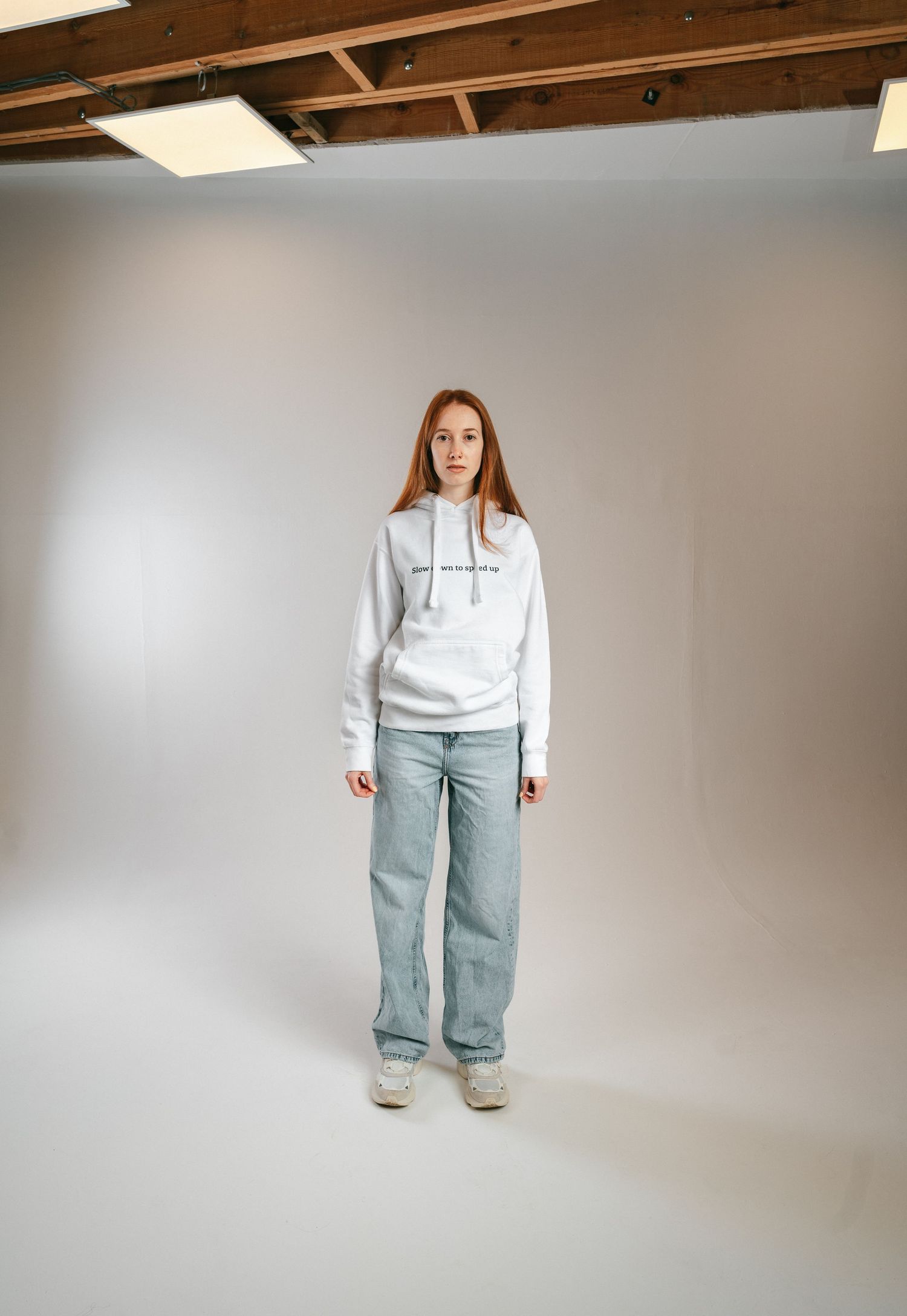 female model wearing white hoodie and blue denim.