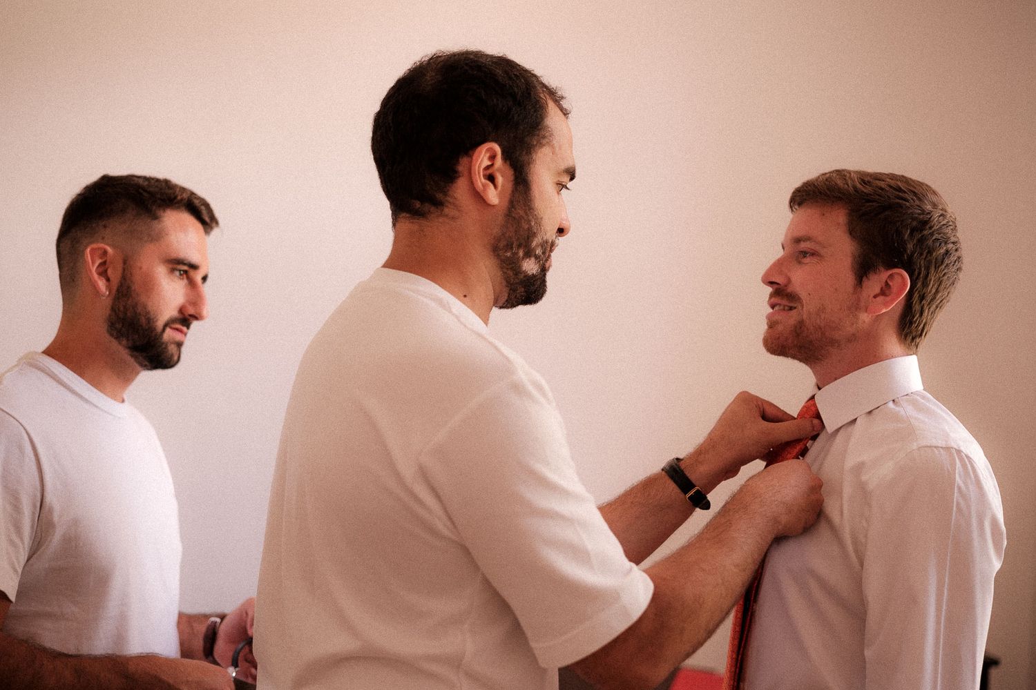 A series of photos showing a man in a white t-shirt trimming his beard with an electric razor.