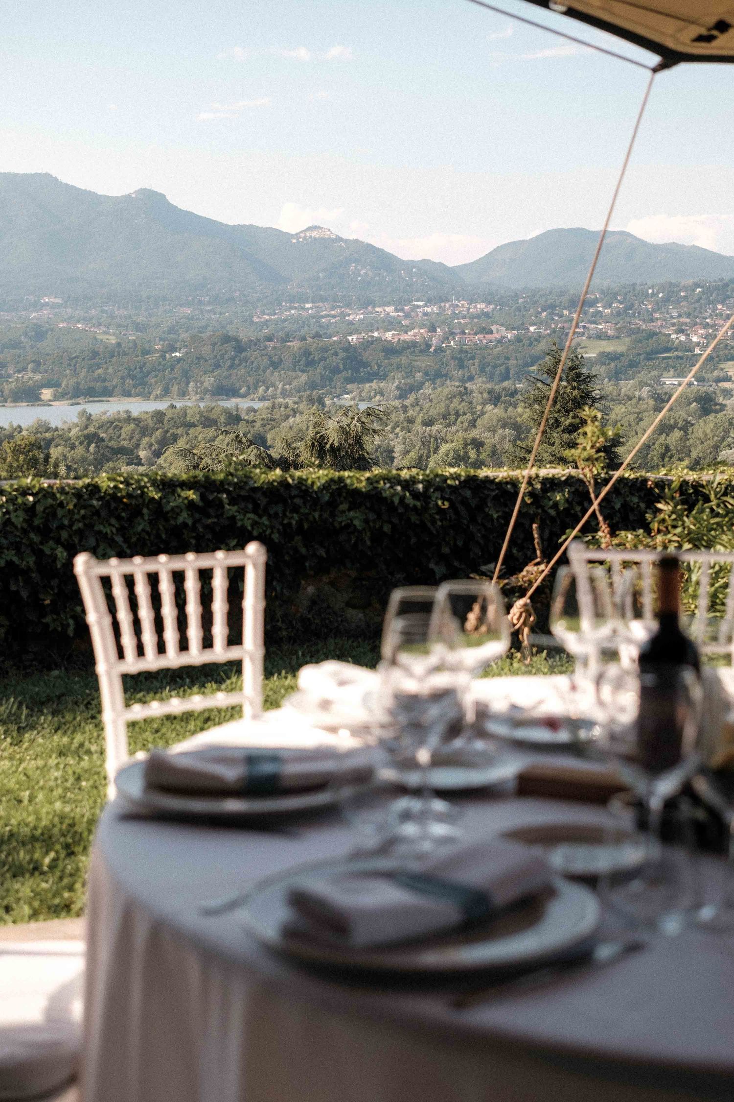 Elegant table settings at an outdoor dining venue with scenic mountain views in the background.