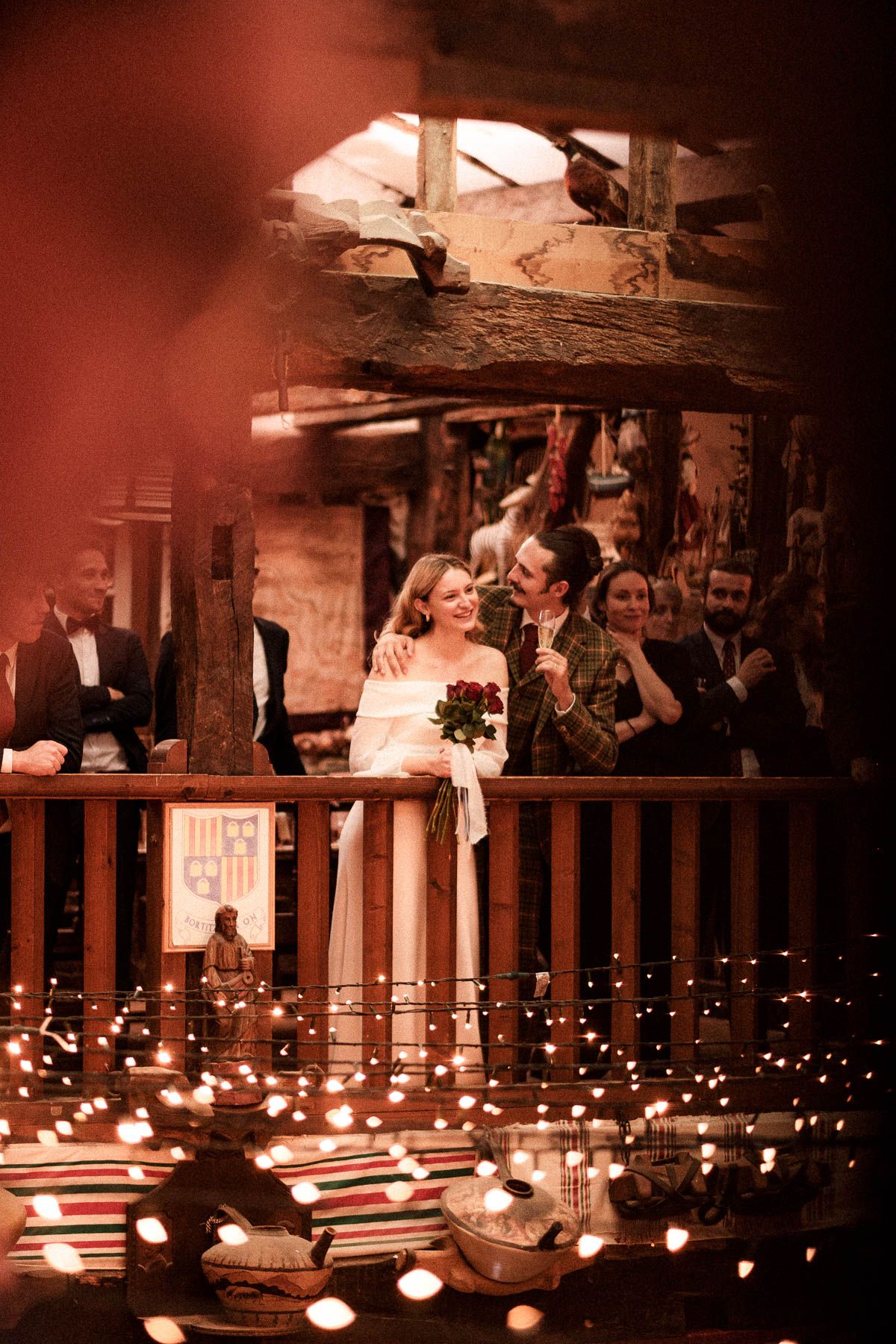 Wedding reception venue at night illuminated by romantic string lights along balcony railings creates magical atmosphere.