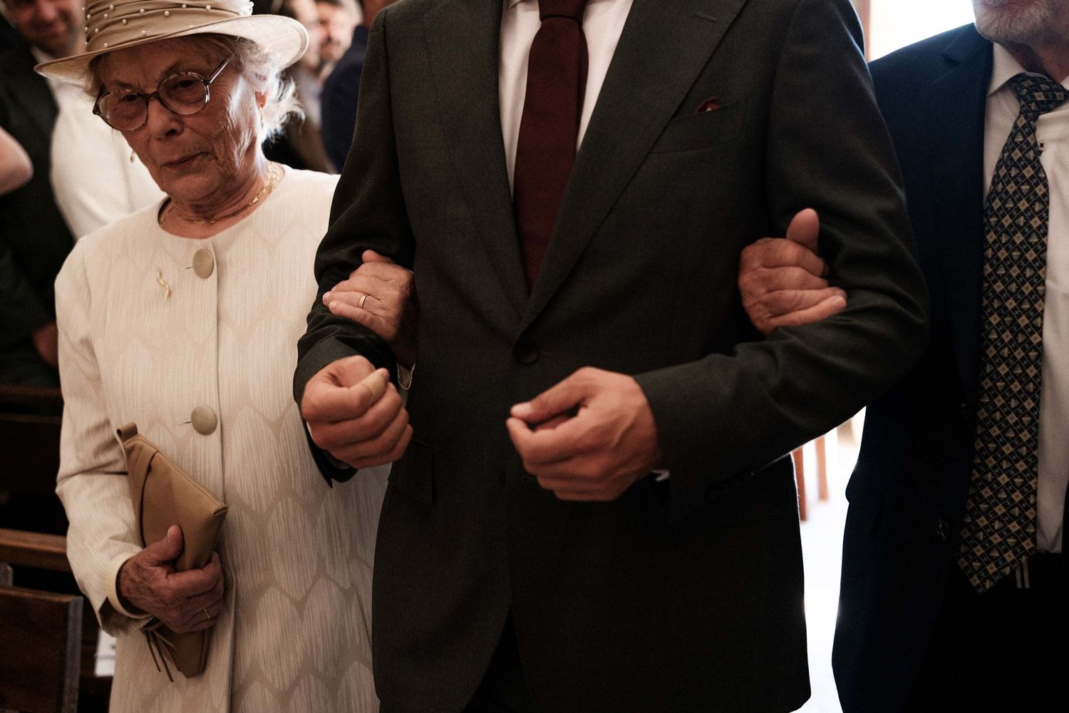 A group of people in formal attire gather together at what appears to be an official ceremony or event.