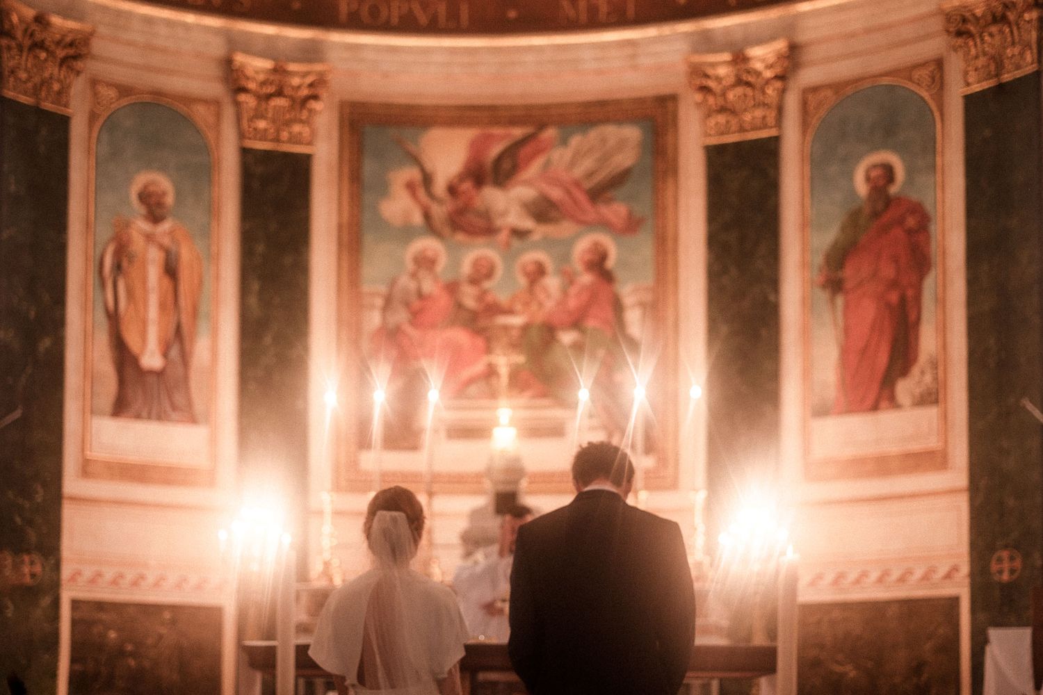 Interior of an ornate church with frescoes on the walls and ceiling illuminated by warm lighting.