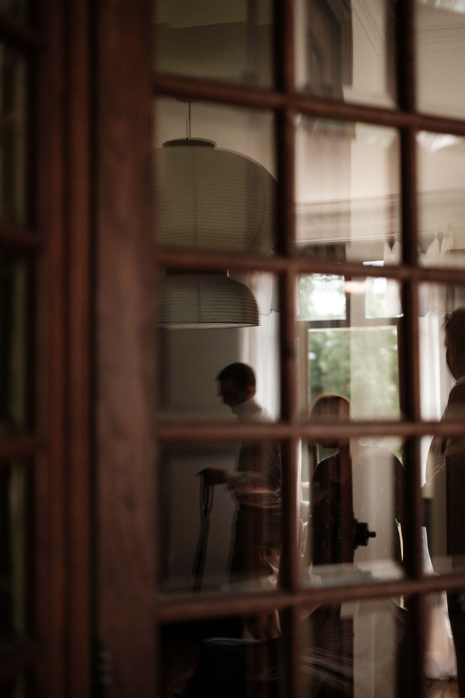 A blurred interior room with wooden beams and windows, creating a moody atmospheric effect in warm tones.