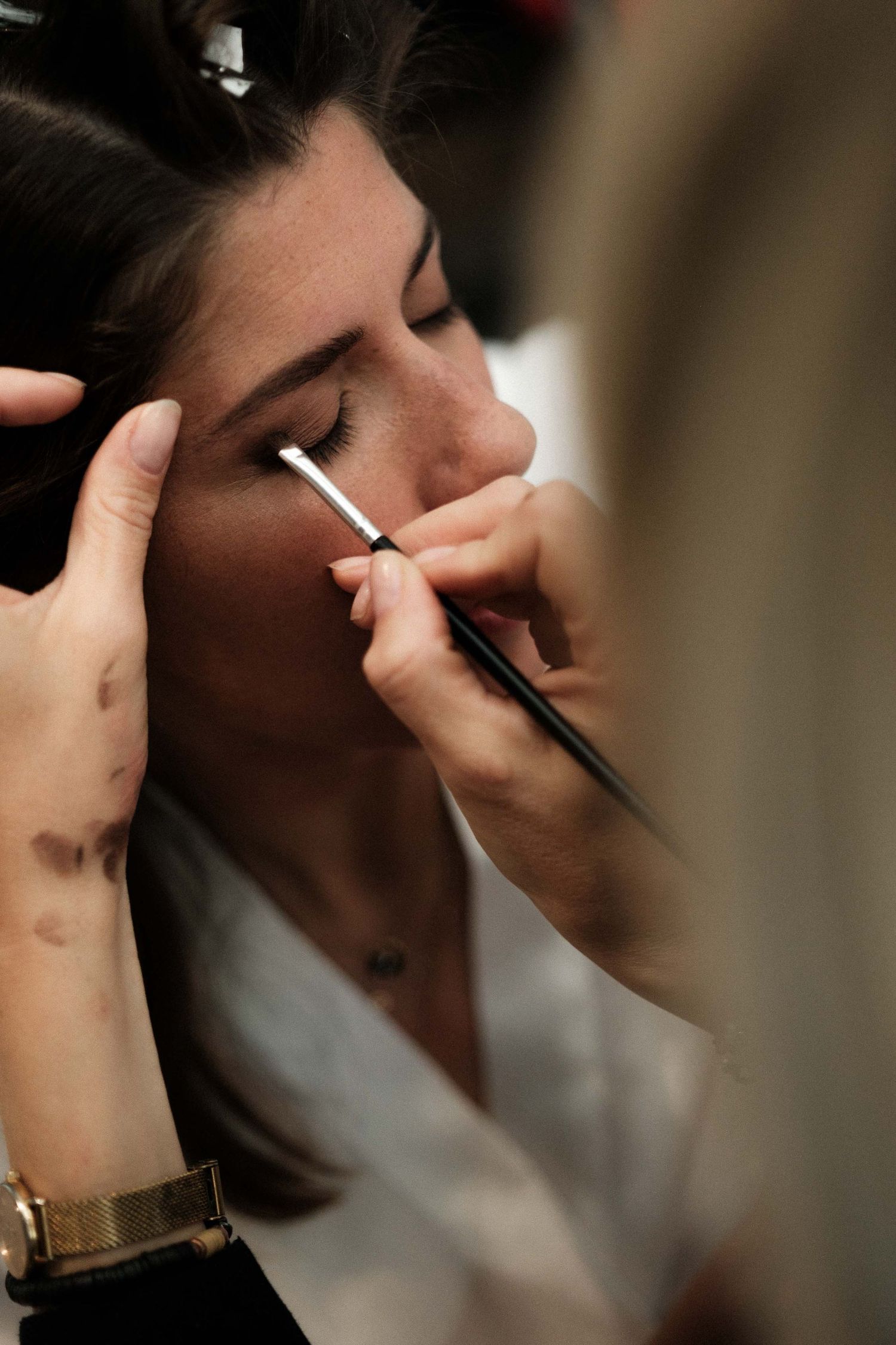 Close-up sequence of someone applying makeup with a brush.