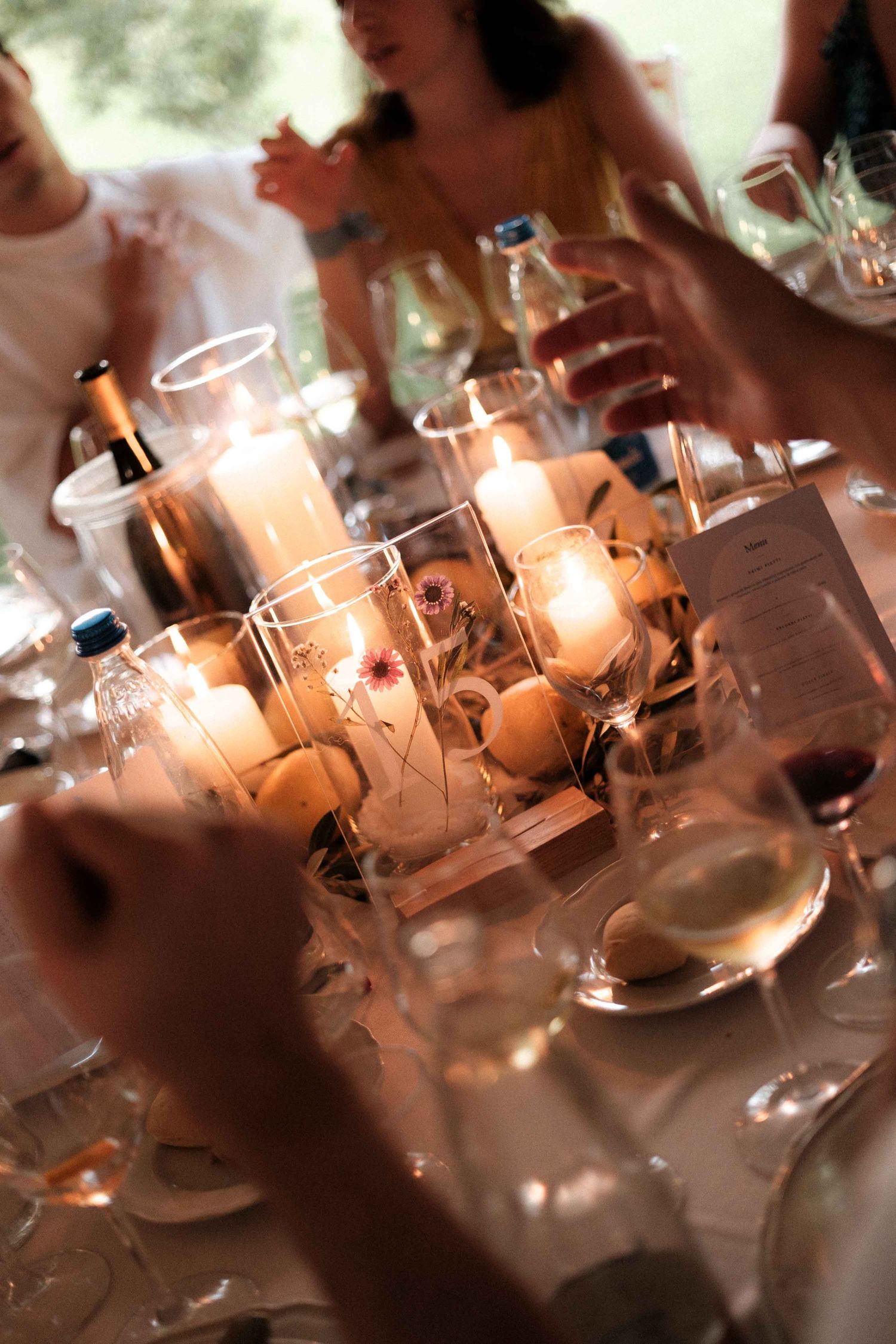Elegant wine glasses and place settings glisten under soft lighting at an upscale dining event.