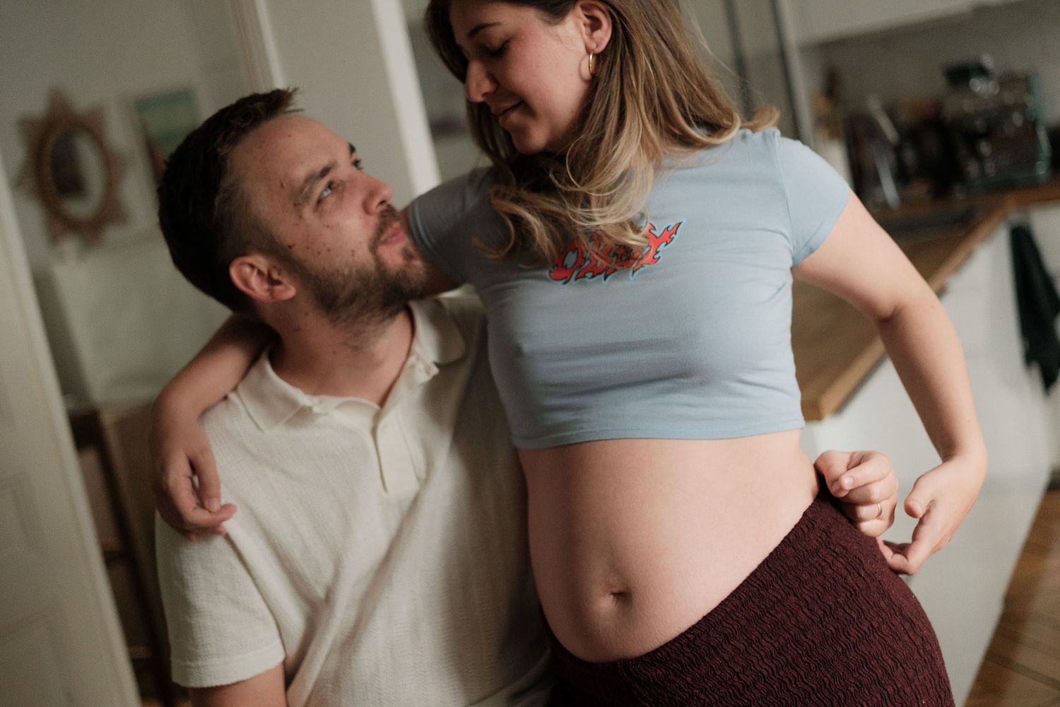 A romantic couple shares tender moments together in a series of intimate indoor photographs.