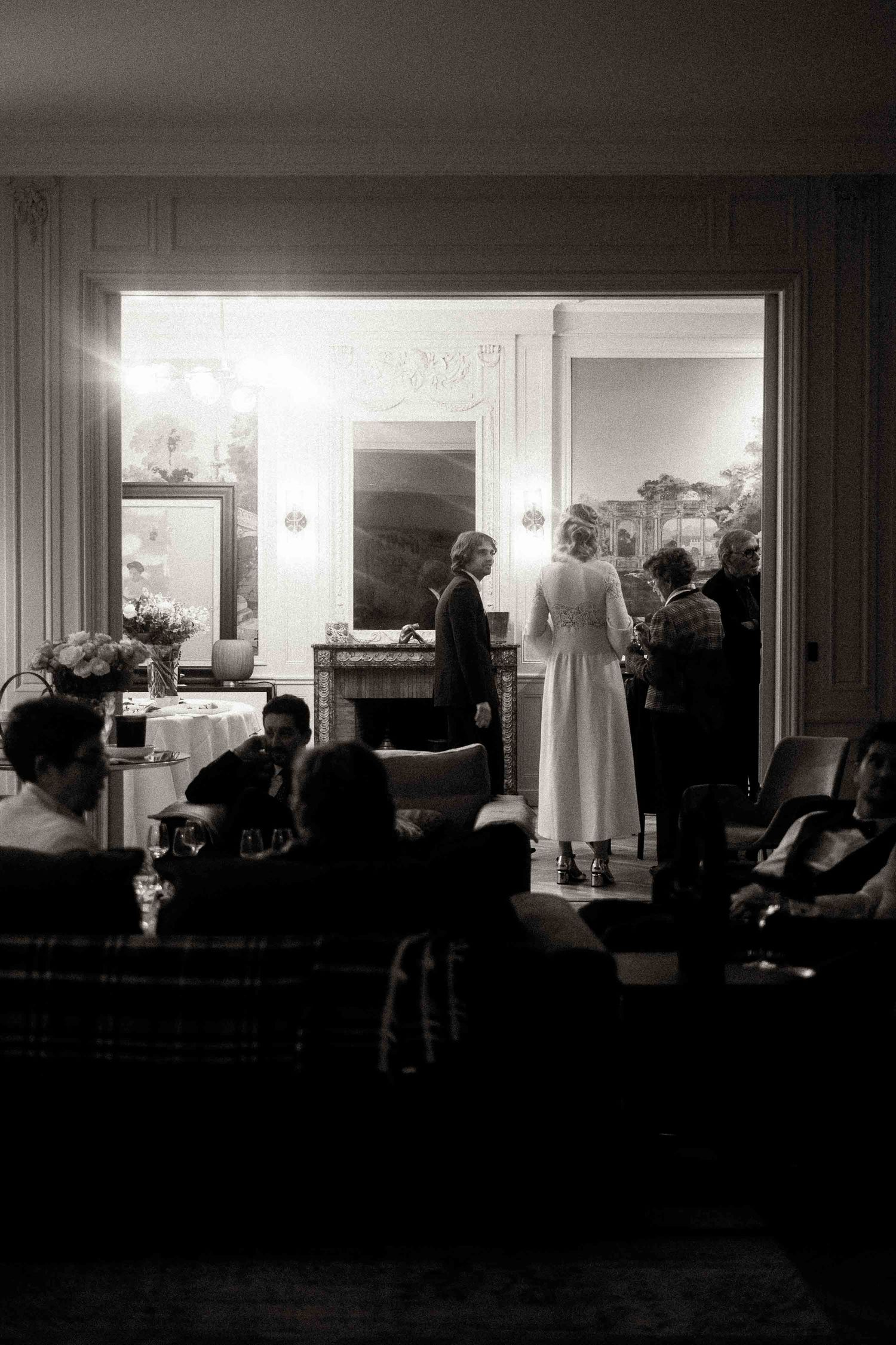 A series of black and white photographs showing silhouettes of people in a darkened interior space.