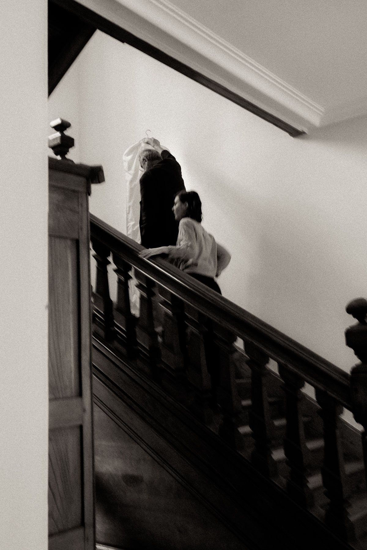 A dramatic black and white sequence shows a silhouetted figure ascending a dark staircase in an eerie composition.
