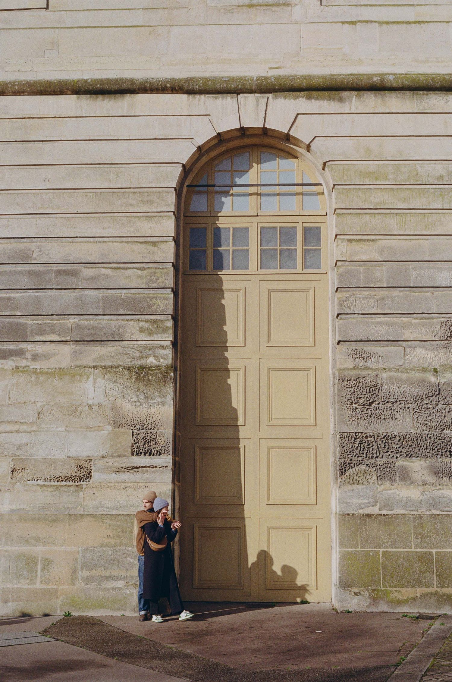 A sequence of four architectural photos showing a beige doorway in a weathered stone wall with shadows cast across it.