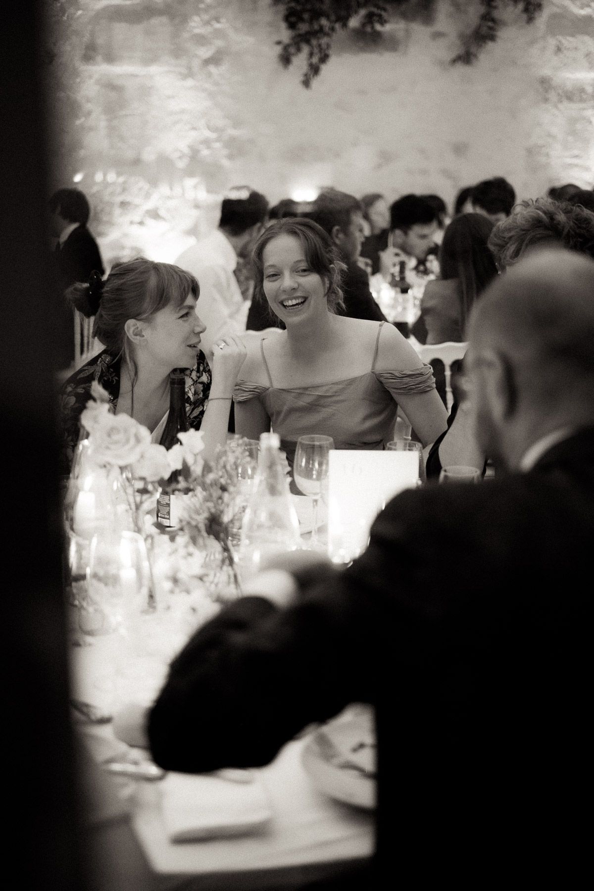 A sequence of black and white candid photos showing people dining and socializing at a restaurant table.