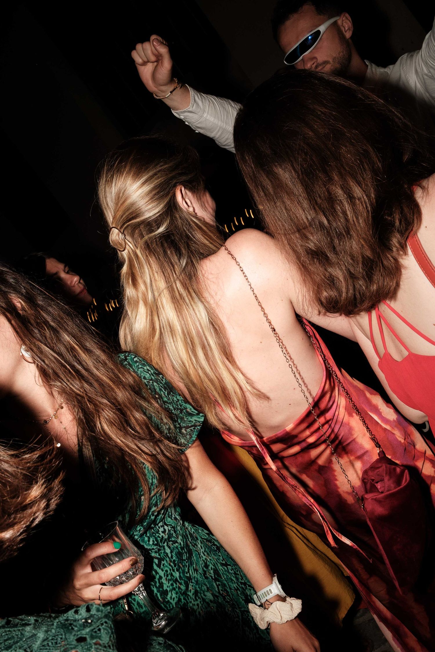 A sequence of dark party photos showing people dancing and moving in dim lighting with someone wearing green and red clothing.