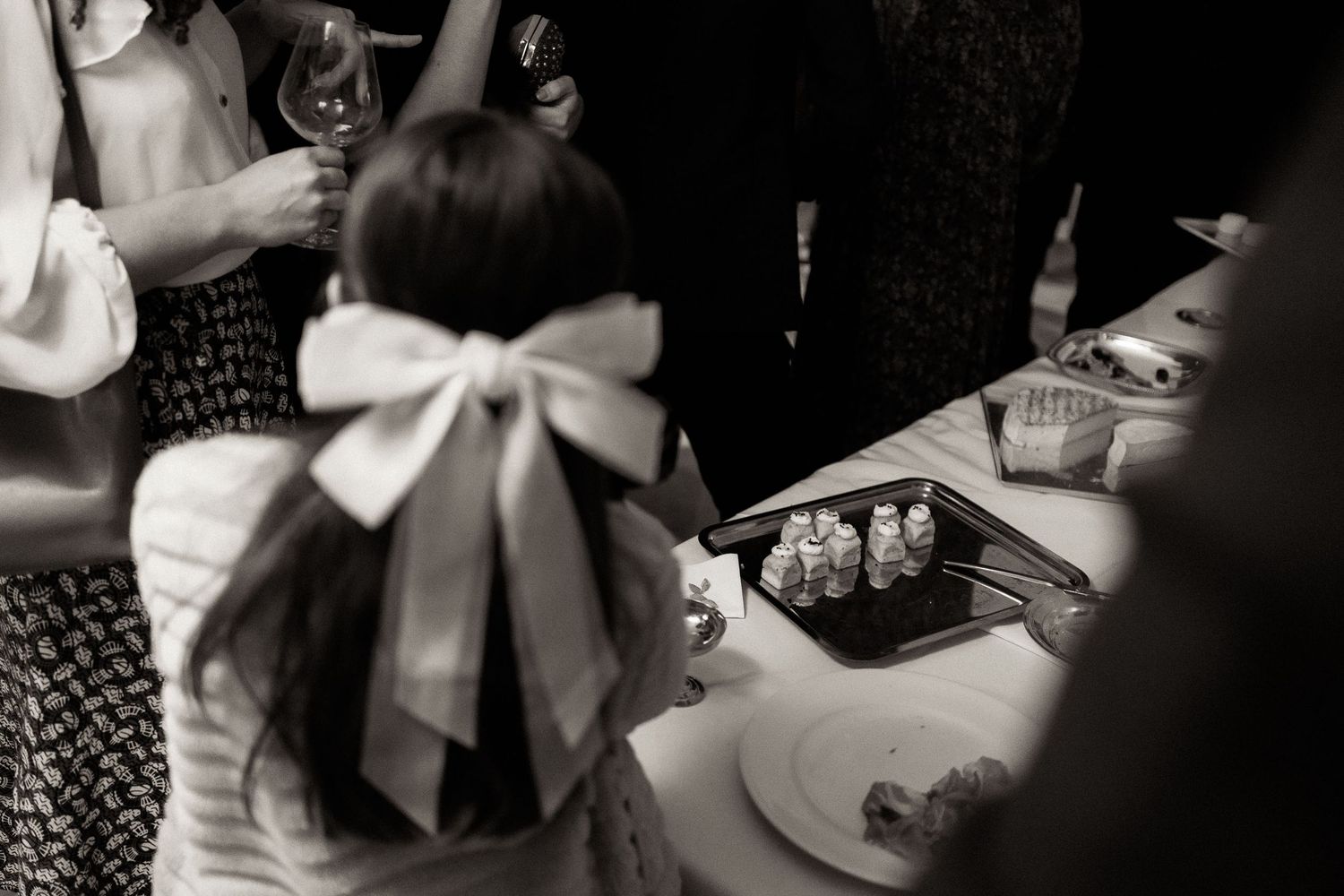 A series of black and white photos showing gift wrapping details with bows and ribbons on presents.