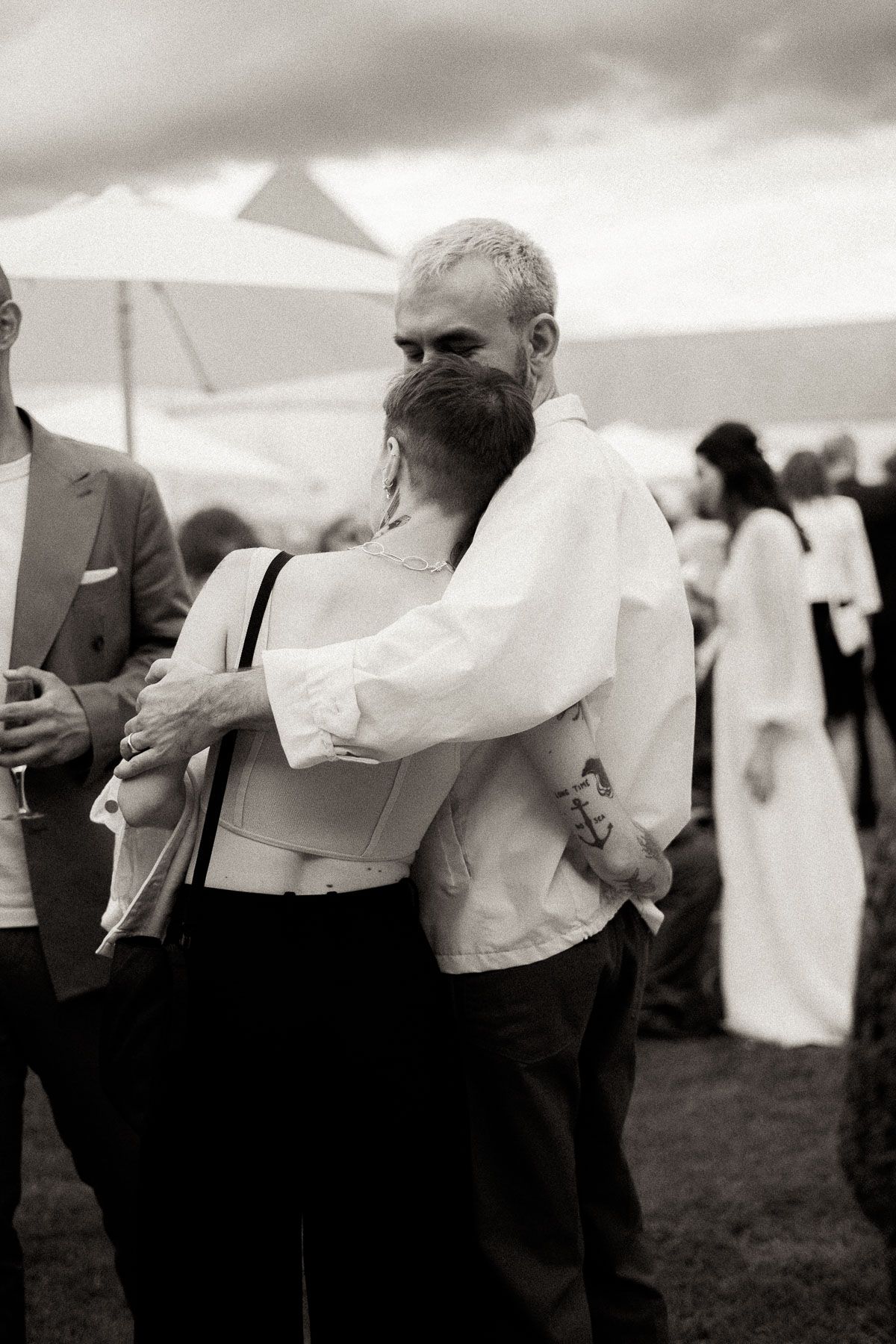 Black and white photo series of couples dancing together at an outdoor event under cloudy skies.