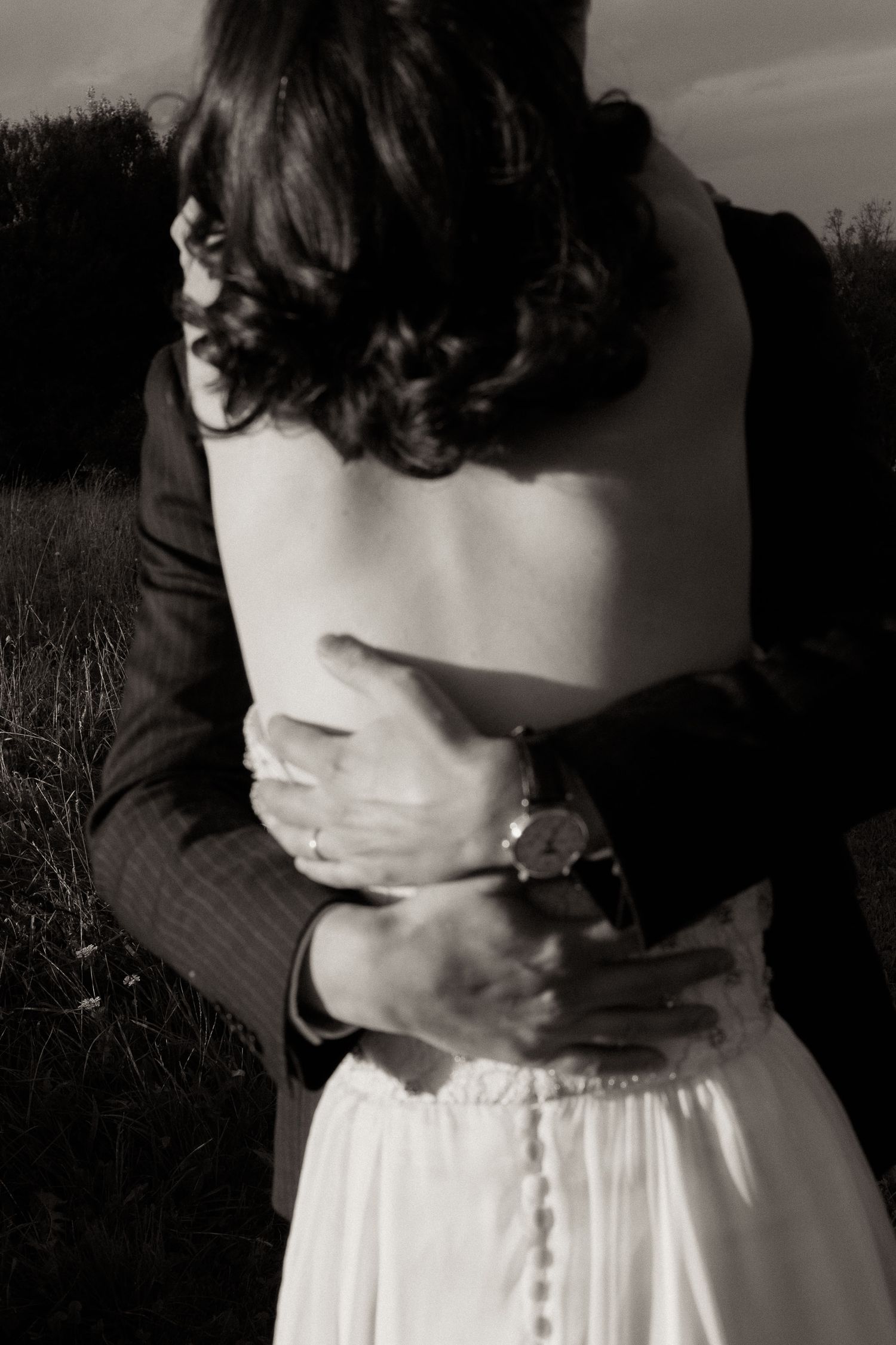 A black and white photo series showing close-up details of a person wearing a white dress with black top.