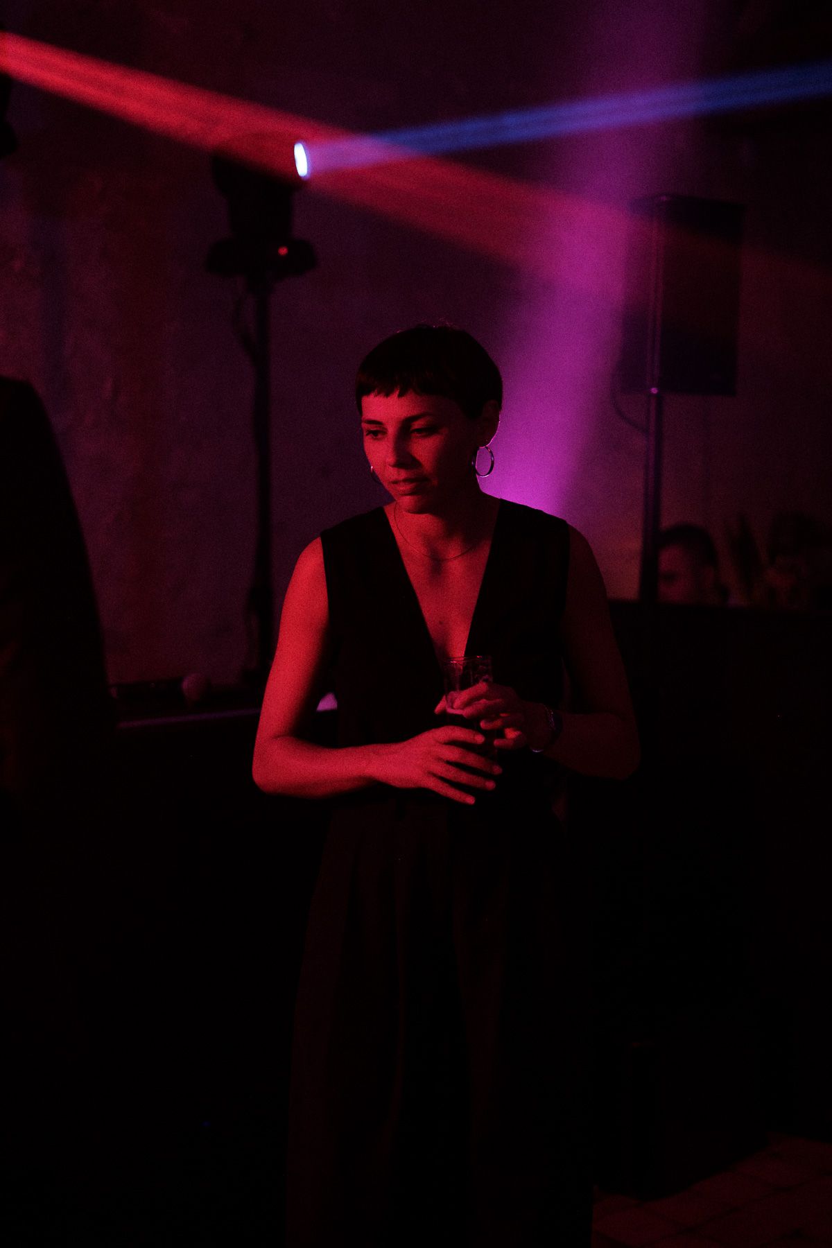 Silhouetted figure illuminated by dramatic red and purple lighting in a dark room.