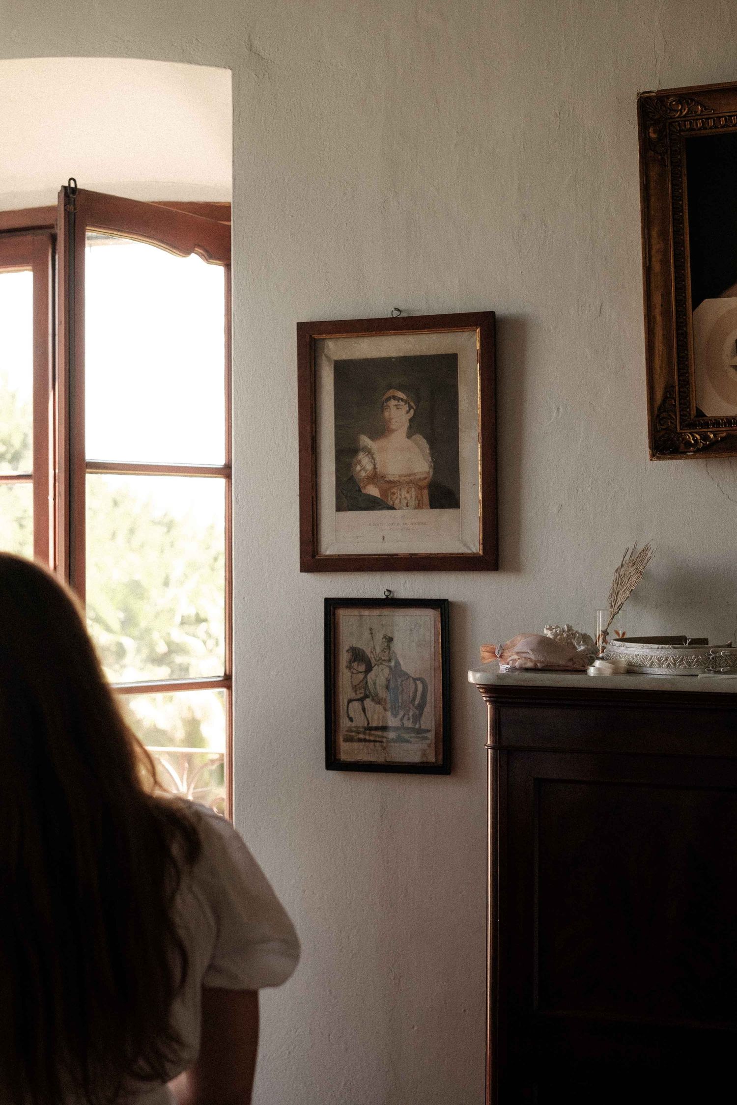 A series of dark interior shots showing windows and framed photographs on walls in moody lighting.