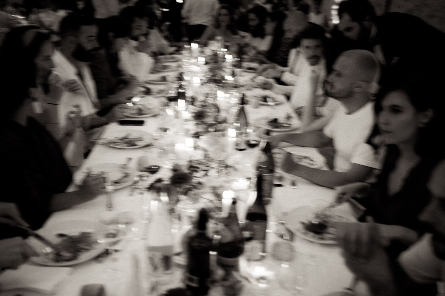 A black and white photo series showing people gathered at tables during a dinner party or restaurant setting.