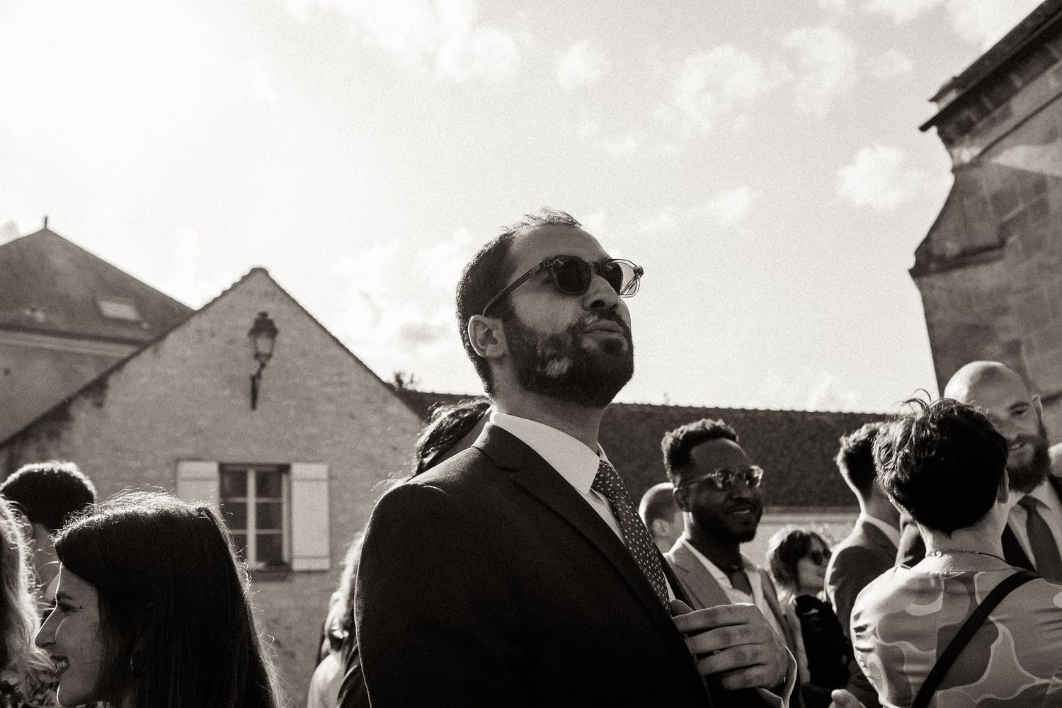 A black and white panoramic photograph shows a crowd of people gathered at an outdoor event or celebration.
