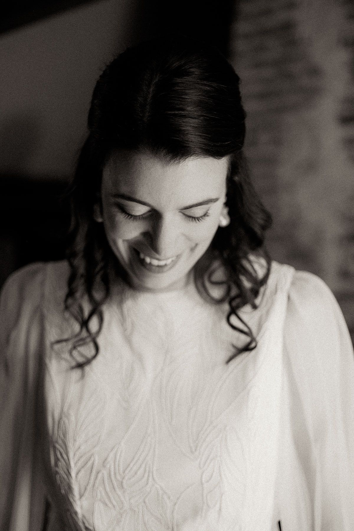 Black and white portrait showing a person wearing an elegant white dress with embroidered details.
