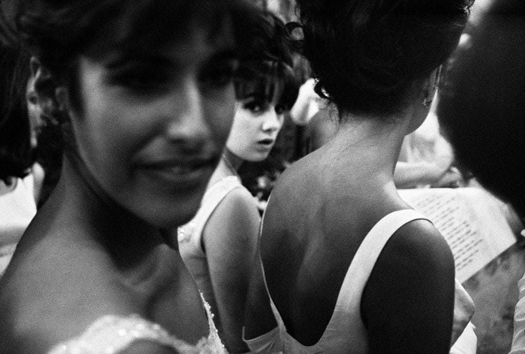 A black and white photo montage shows multiple candid expressions and close-up portraits of people.