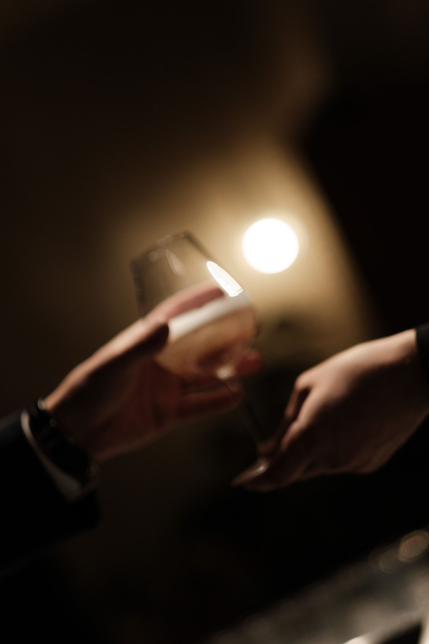 A series of hands passing a lit cigarette in a dark setting with dramatic lighting effects.