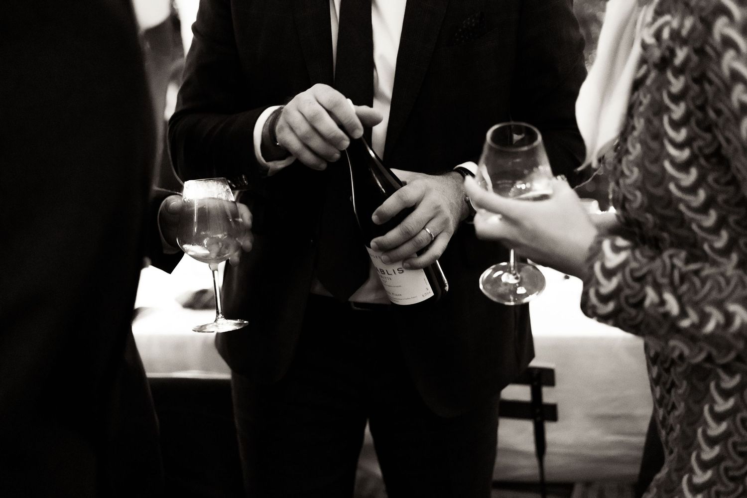 People in formal attire hold champagne glasses at an elegant event.