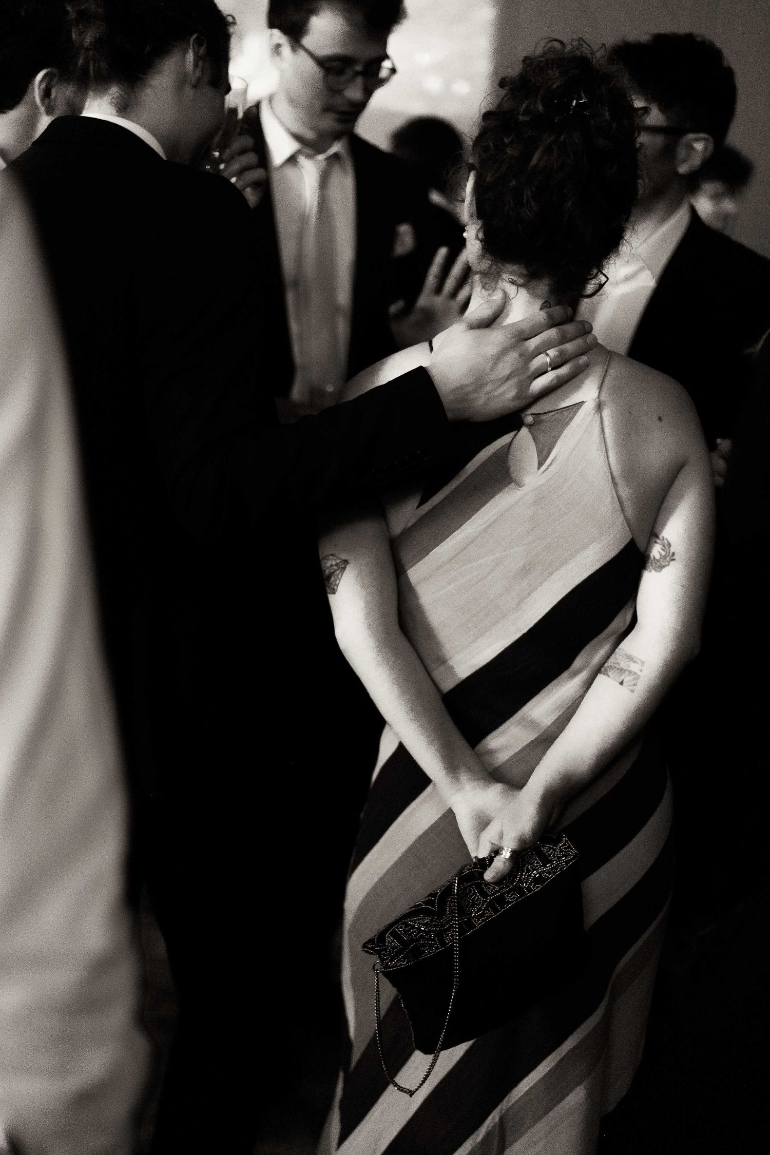 A romantic black and white photo series showing a couple in formal attire dancing closely together at an event.