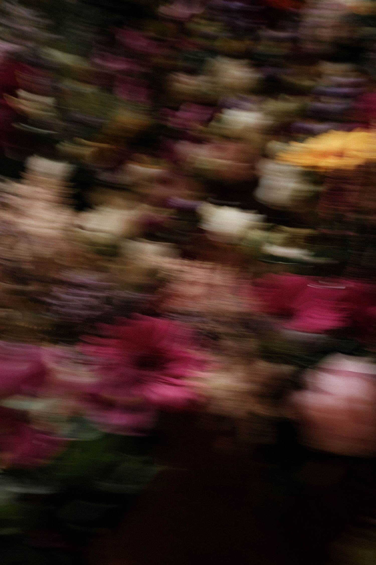 Motion blur of pink and purple flowers creates an abstract artistic effect in nature.