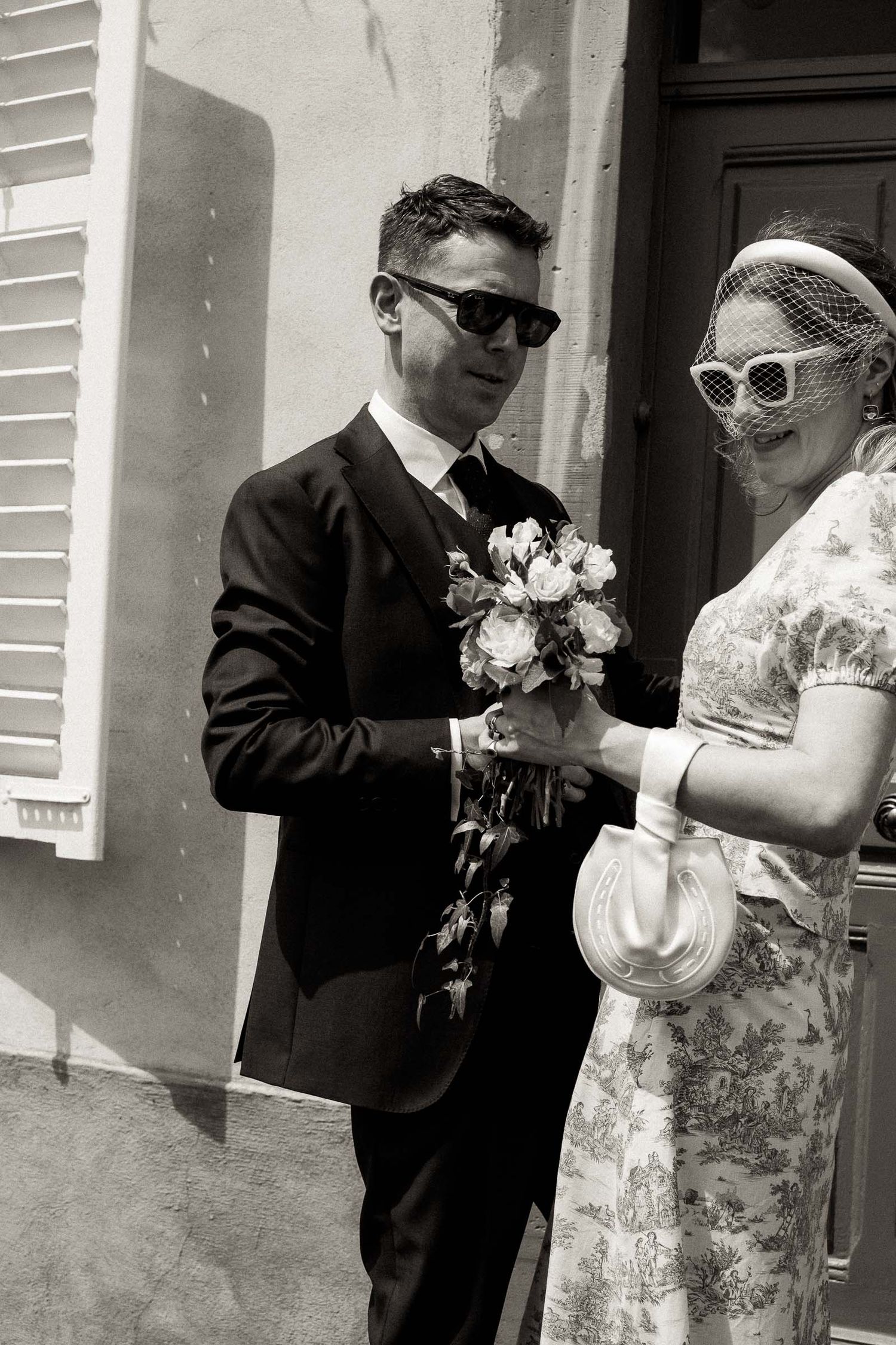 A black and white wedding photo sequence showing a couple in sunglasses and formal attire sharing a joyful moment outdoors.