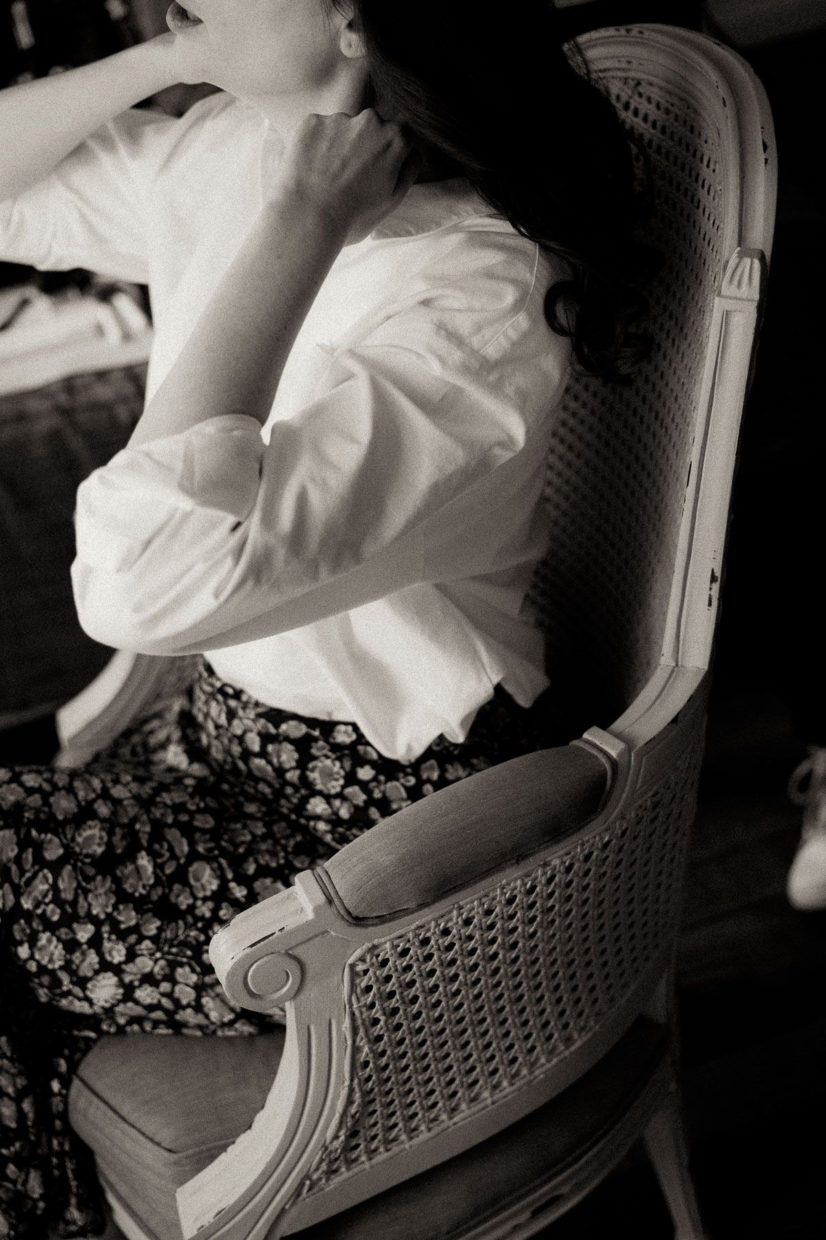Close-up black and white photo of a white sneaker and floral patterned fabric creating artistic contrast and texture.