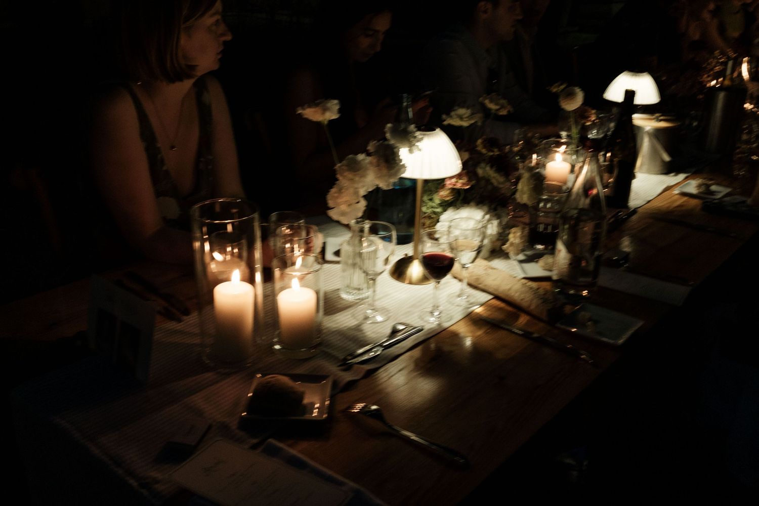 A romantic candlelit table setting at a restaurant with elegant glassware and soft lighting creates an intimate ambiance.