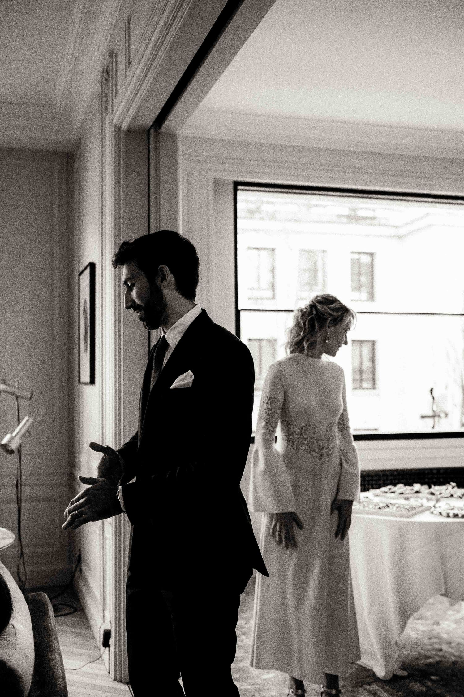 A series of black and white wedding photos showing intimate moments between a couple in a bright interior setting.