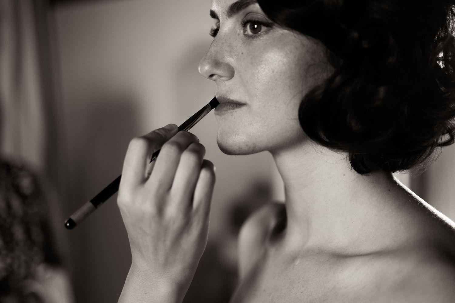 A black and white photo sequence showing someone applying lipstick in six different close-up shots.