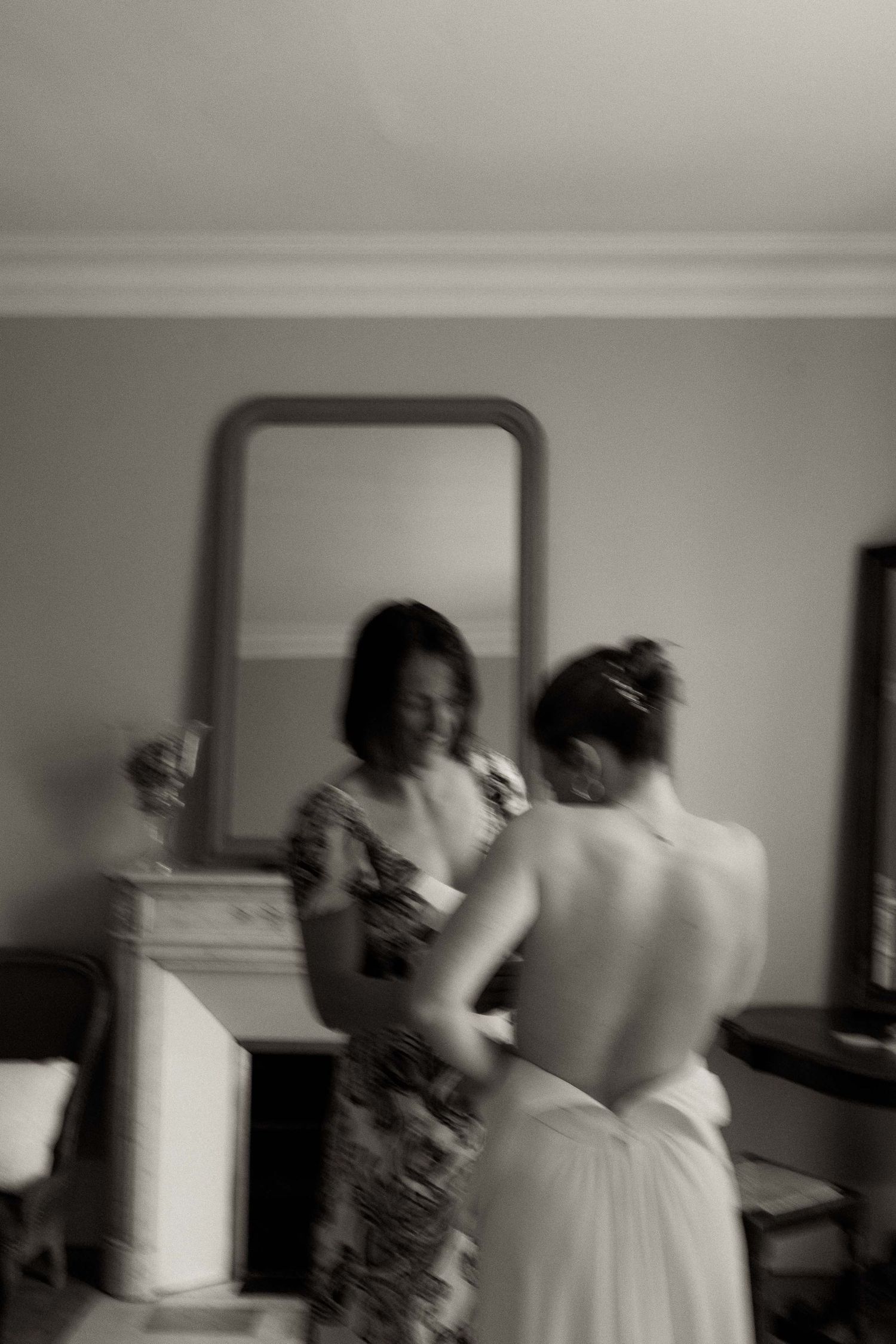 A blurry black and white sequence of people in motion inside a room.