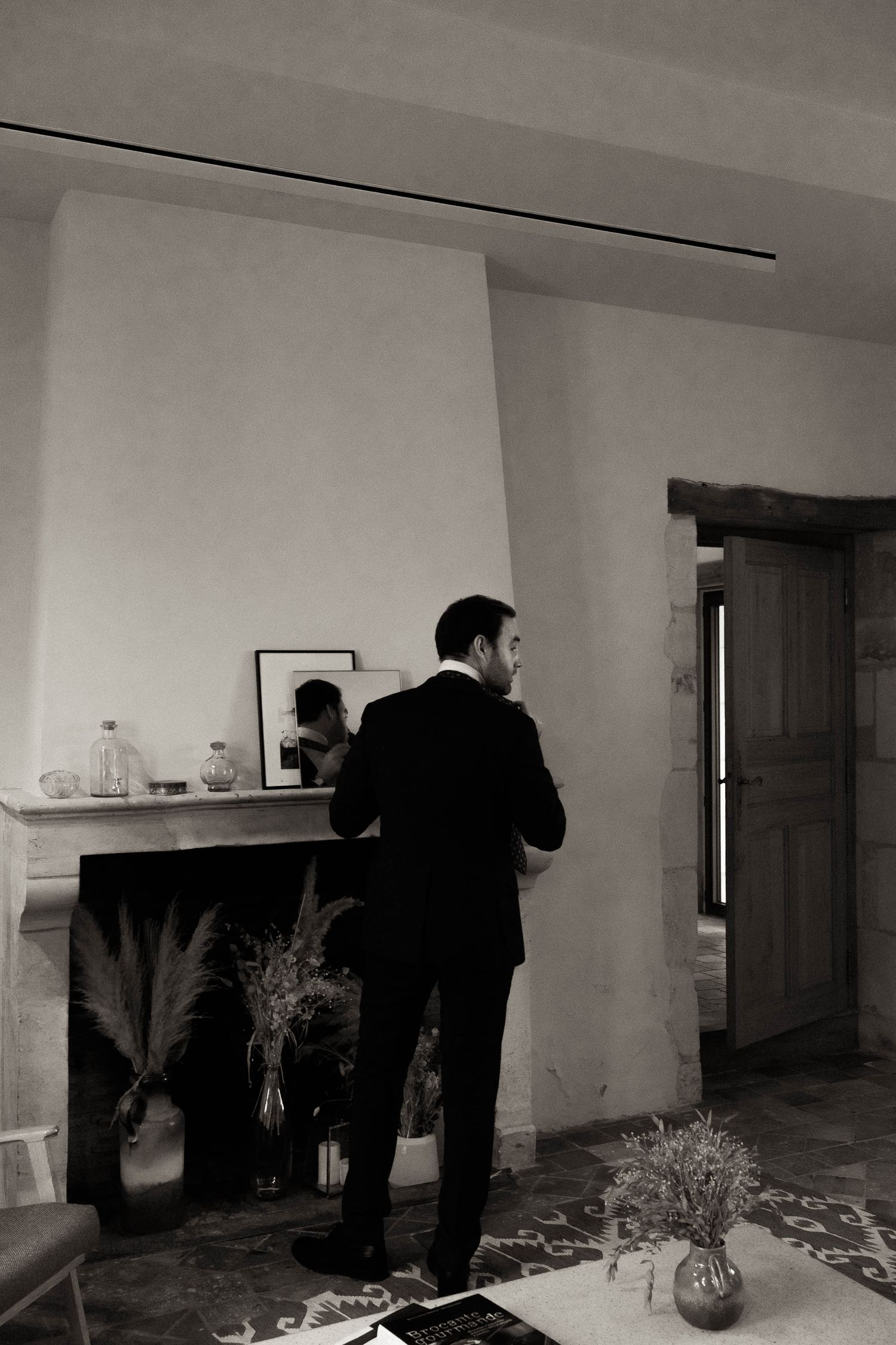 People examining objects on display shelves in a dimly lit gallery or exhibition space.