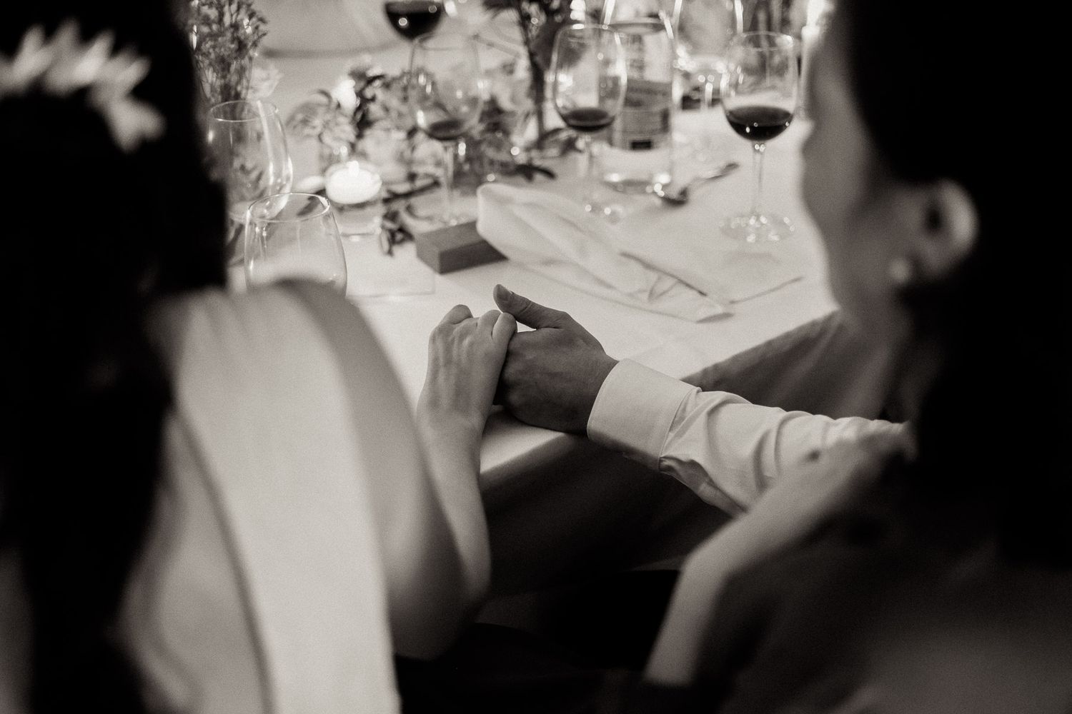 A formal dinner table setting with wine glasses and place settings shown in black and white photography.
