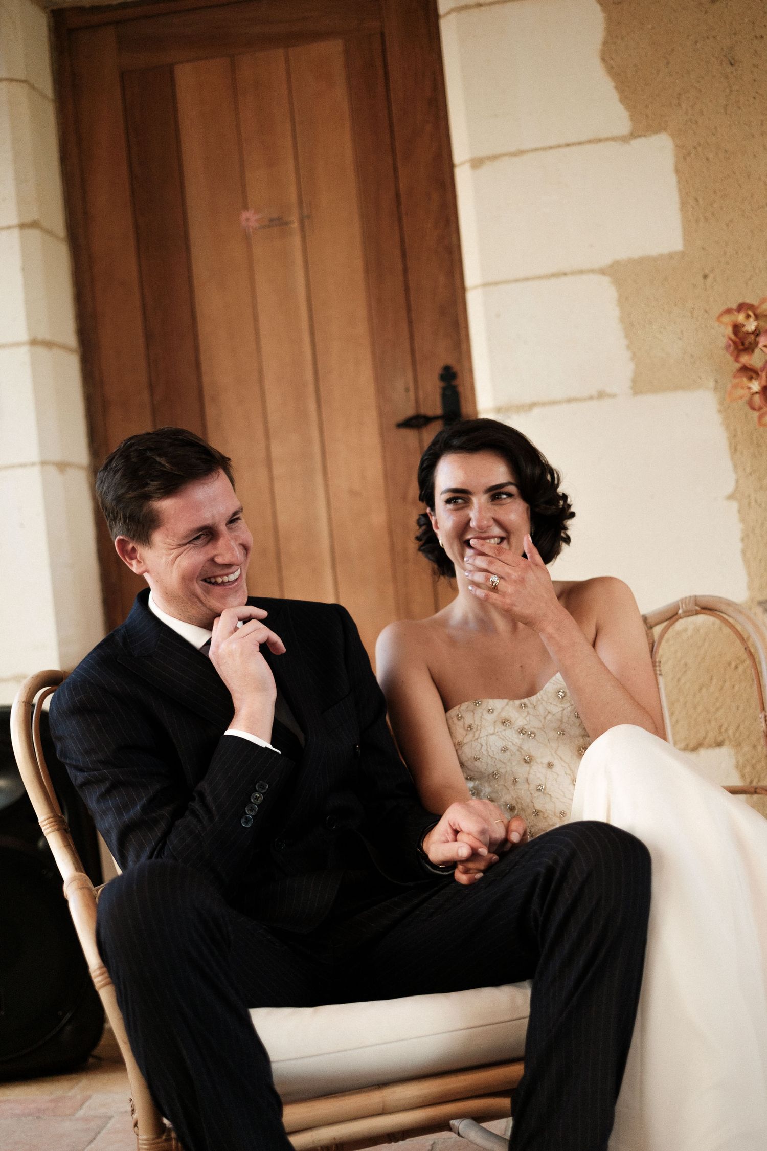 A wedding couple shares a candid laughing moment together on a bench in a series of four connected photos.