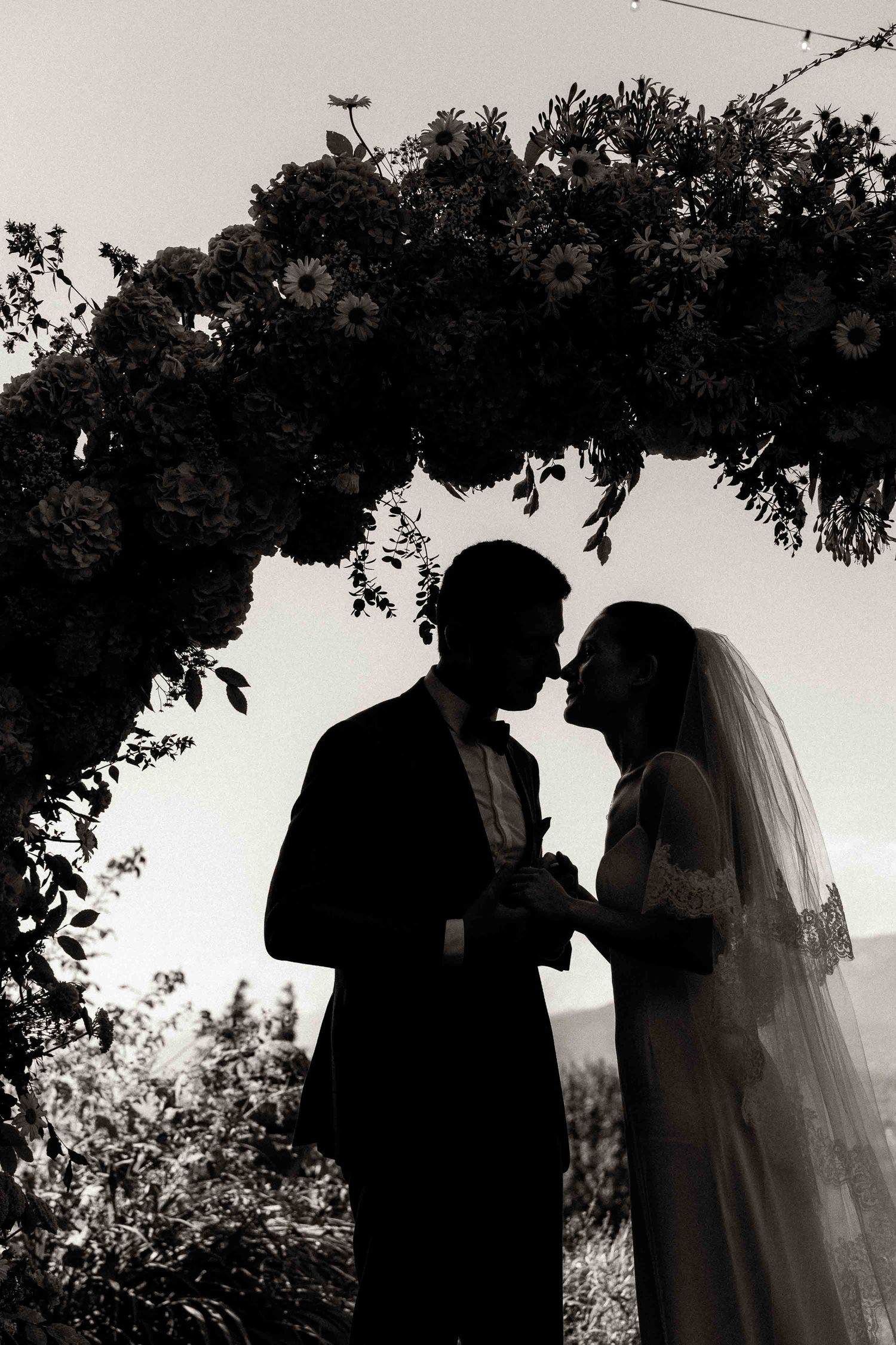 A romantic black and white wedding photo sequence showing silhouettes of a couple in five progressive frames.