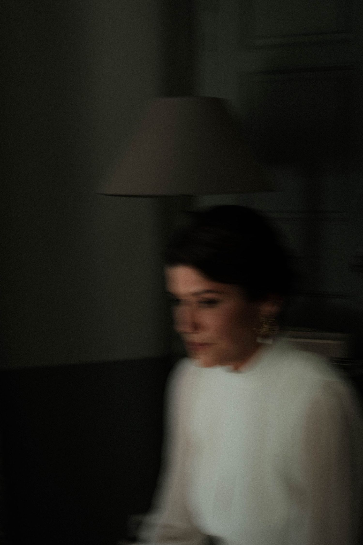 A person in a white top moves through a dark space creating a blurred motion effect in a sequence of images.