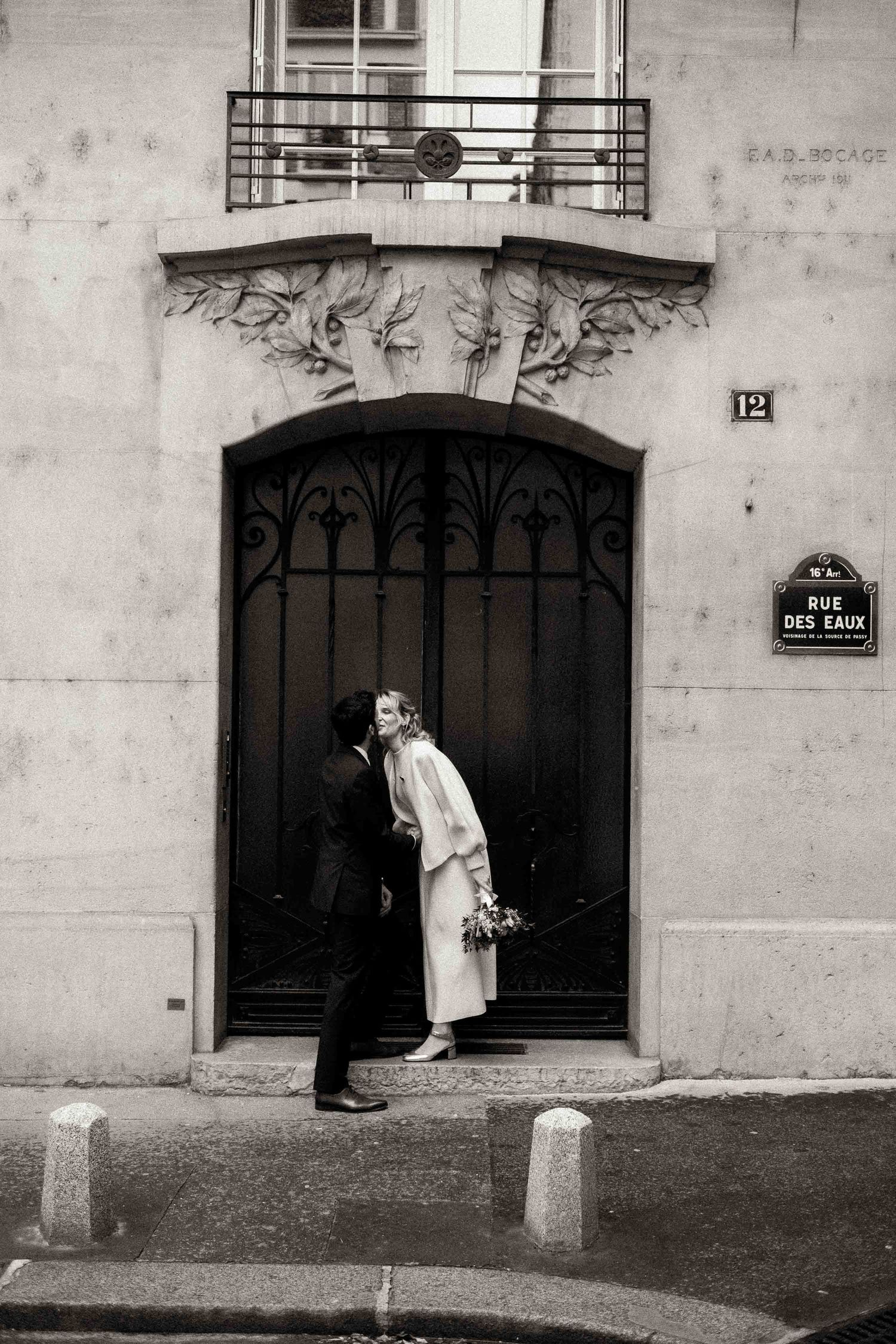 A black and white photo series showing a person in white clothing peeking around corners of a building's entrance.