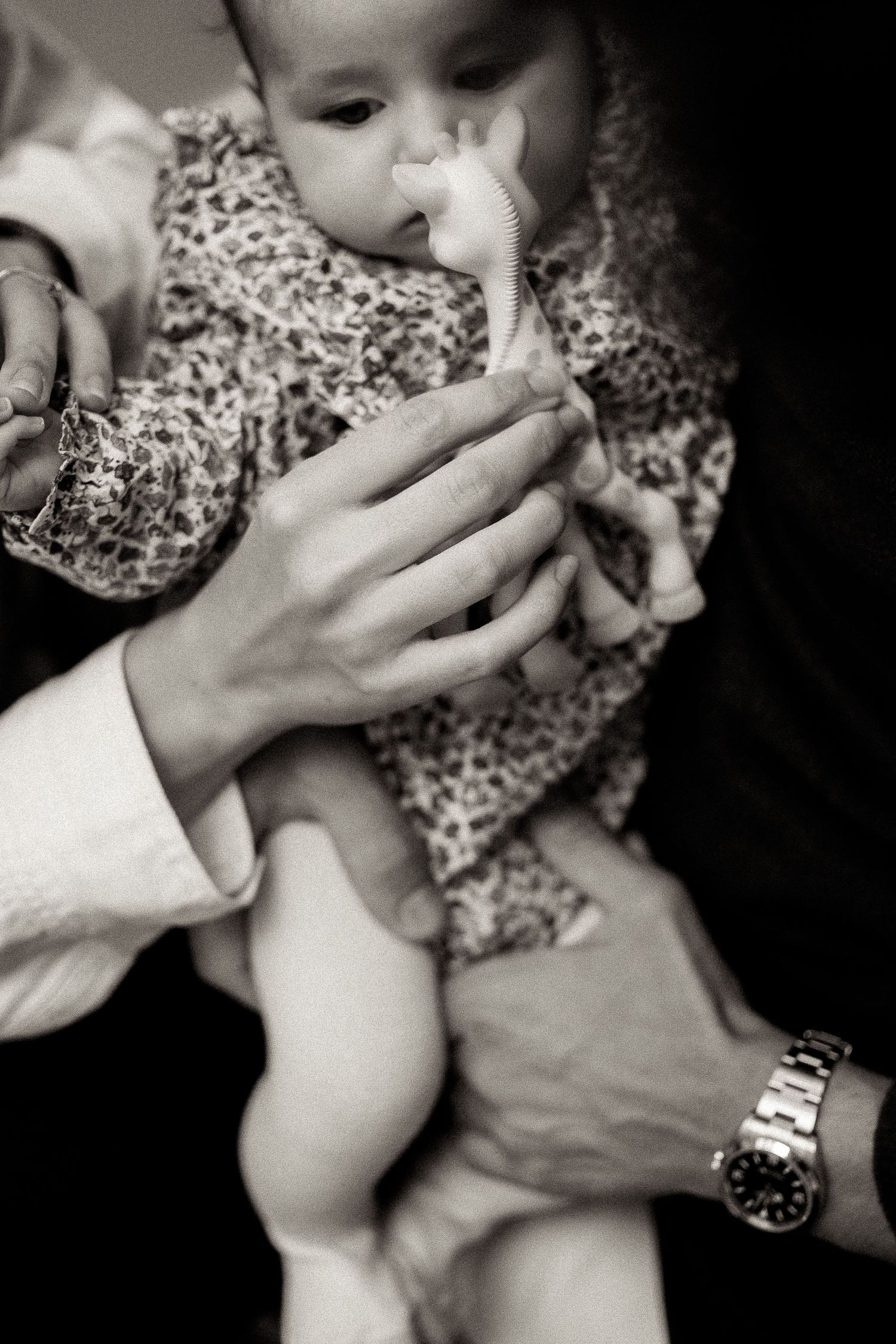 A series of black and white photos showing hands feeding a small baby from a bottle in similar poses.