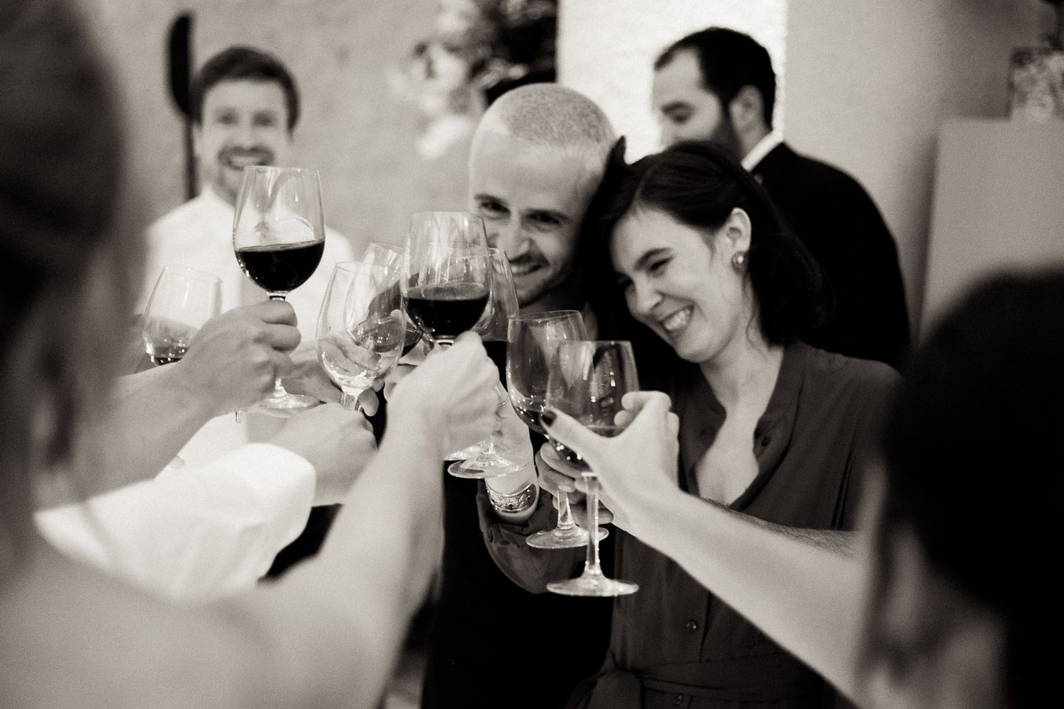 People enjoying wine and conversation at a social gathering in black and white photography.