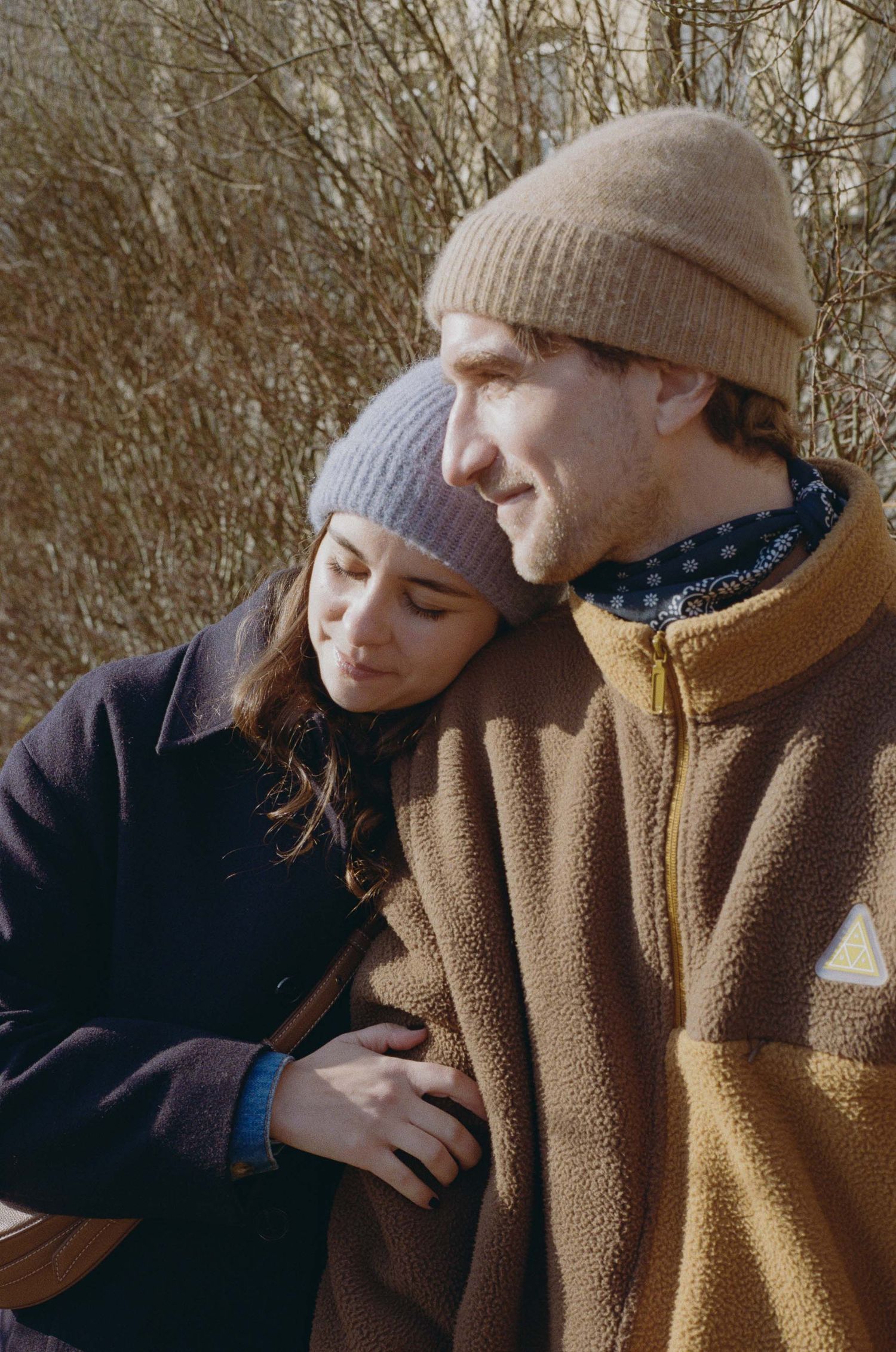 A series of intimate photos showing two people in winter attire sharing tender moments together.