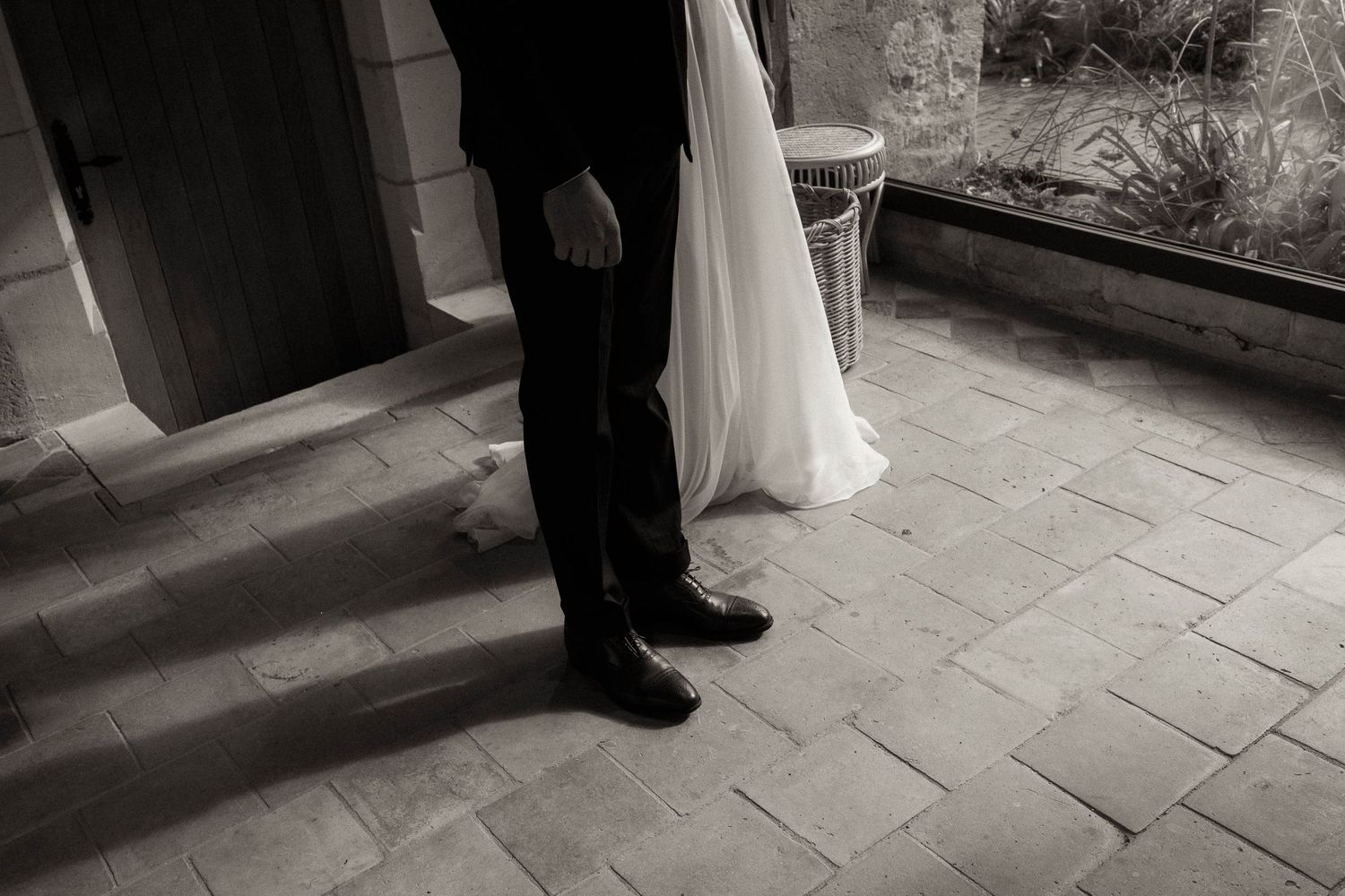 A series of black and white wedding photos showing formal attire and elegant poses on stone steps.