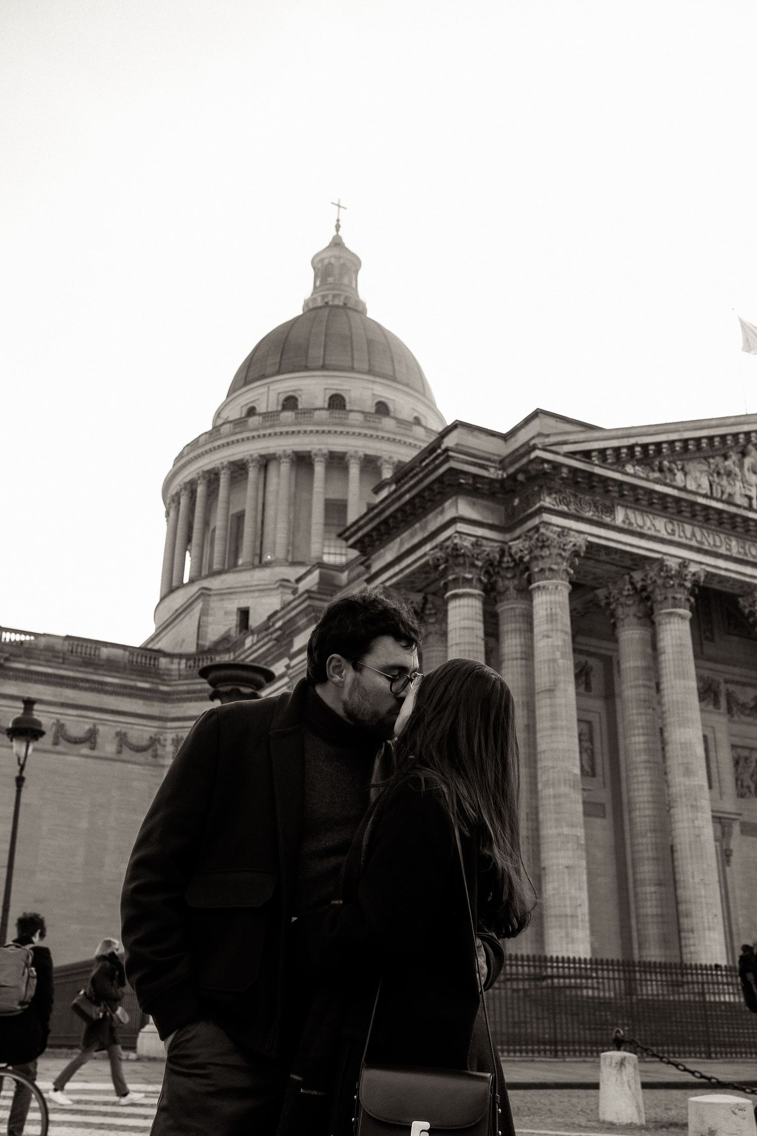 A couple shares a romantic moment outside the historic Pantheon building in Paris.