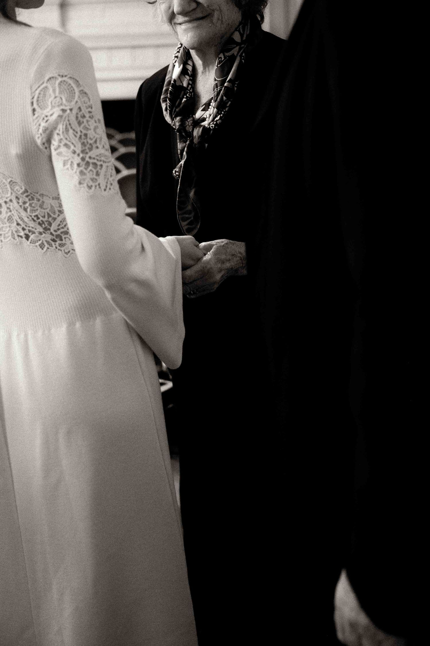 Black and white wedding photo series showing close-up details of a bride's lace dress and intimate moments.