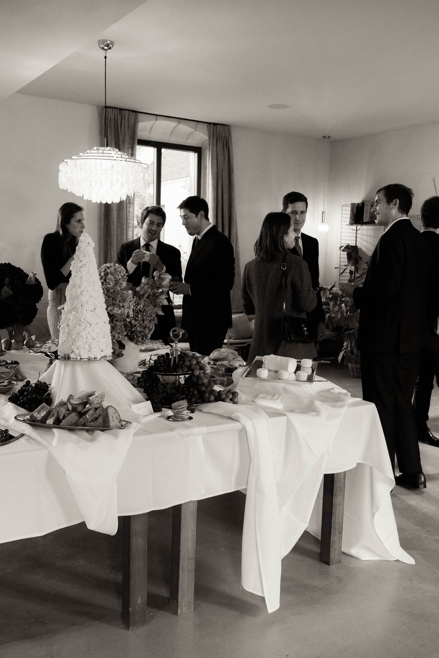 Black and white photo series showing a wedding cake display table at an elegant indoor reception venue.