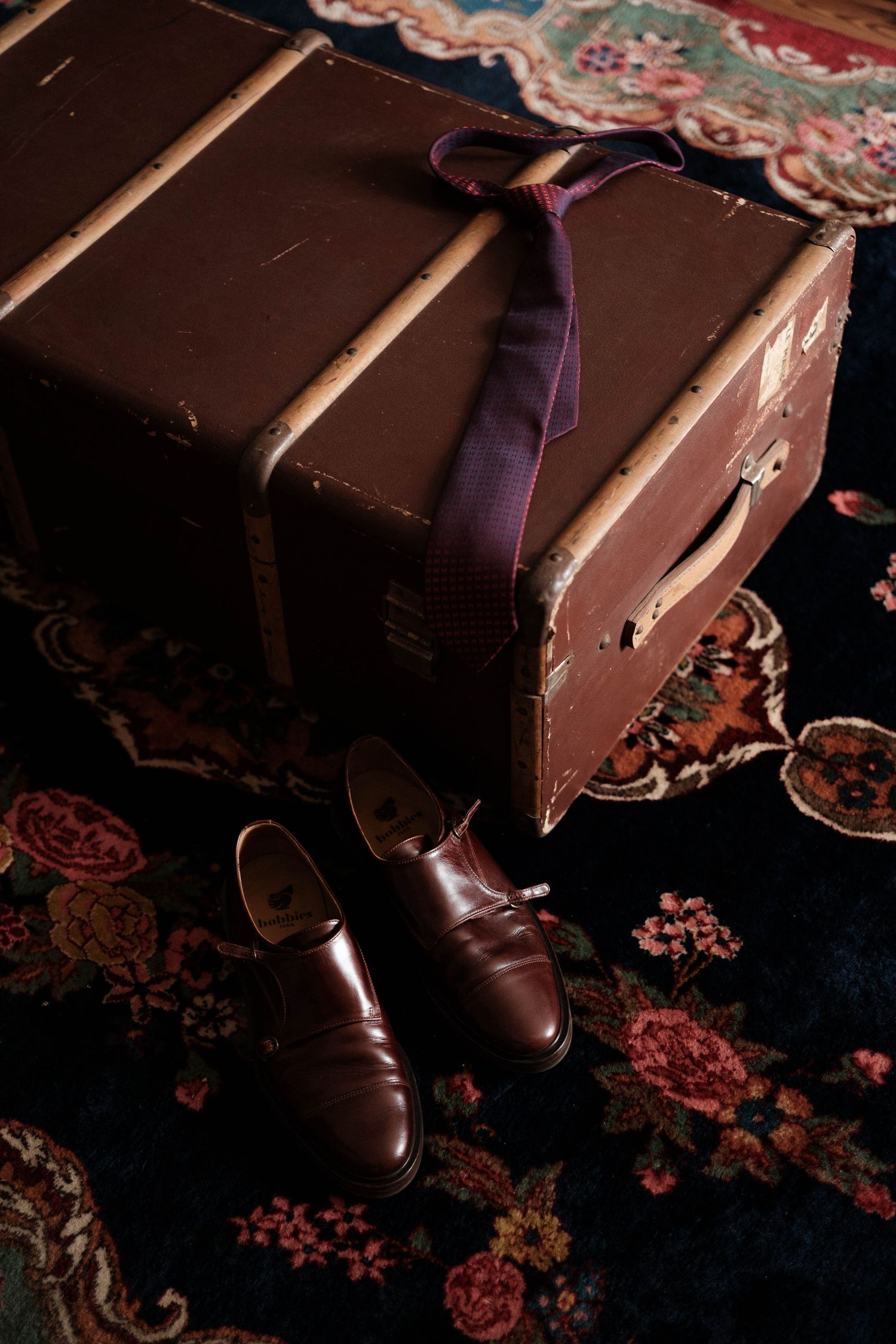 Close-up of dark chocolate pieces with cocoa powder on black background in moody lighting.
