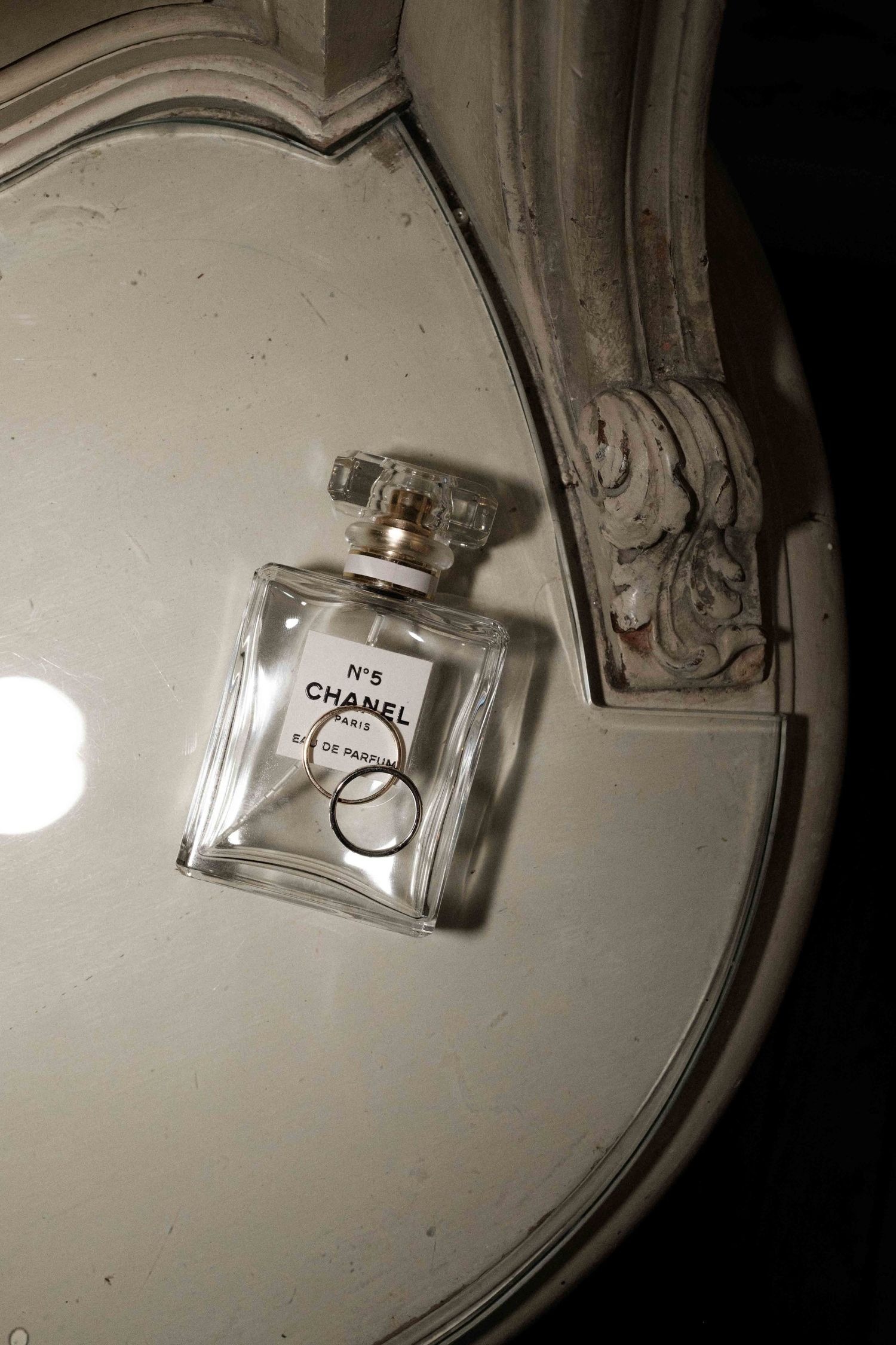 A series of four similar shots showing a Chanel perfume bottle on a white surface with dramatic side lighting.