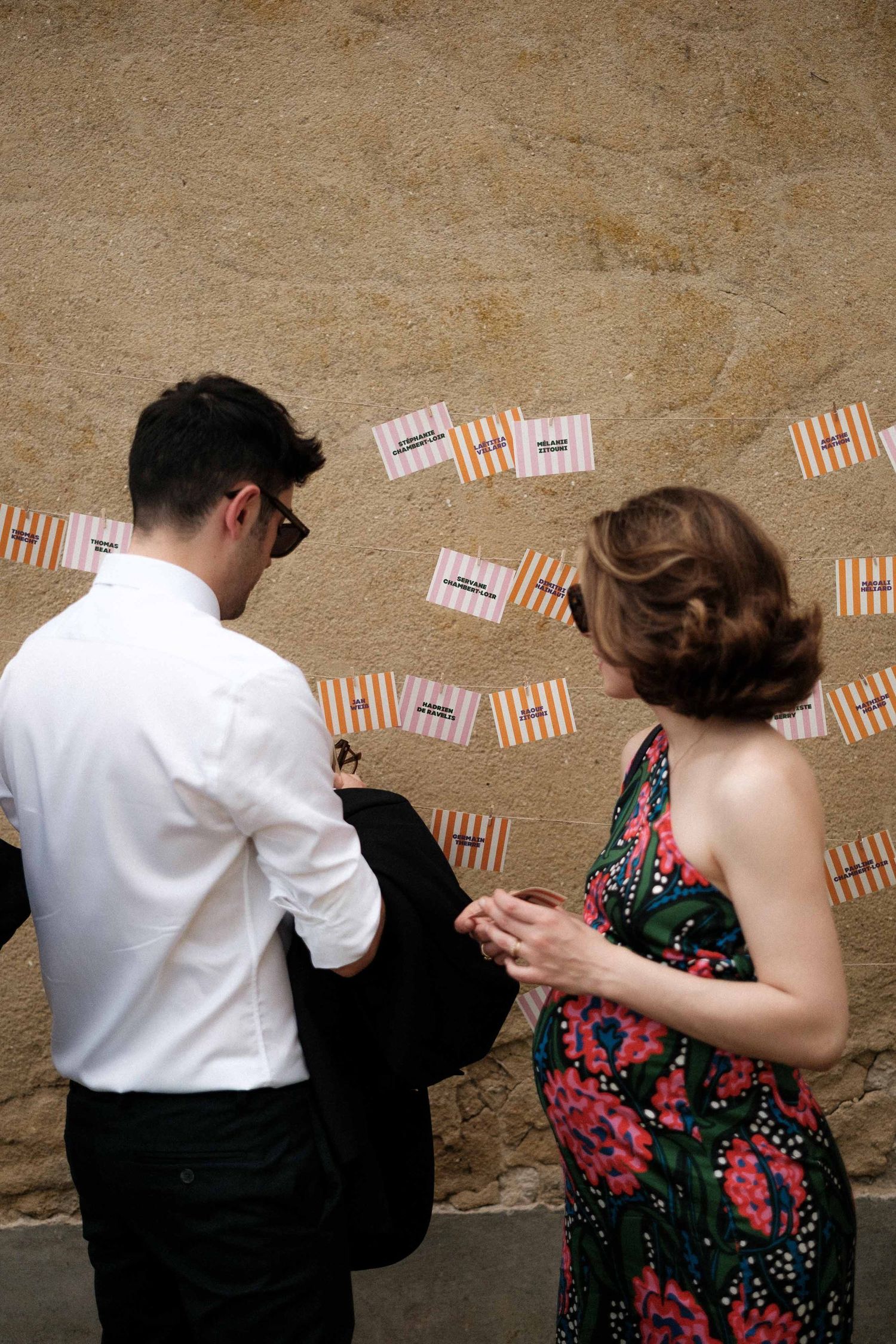 A couple dances together in front of a wall decorated with small striped banners in a sequence of five photos.